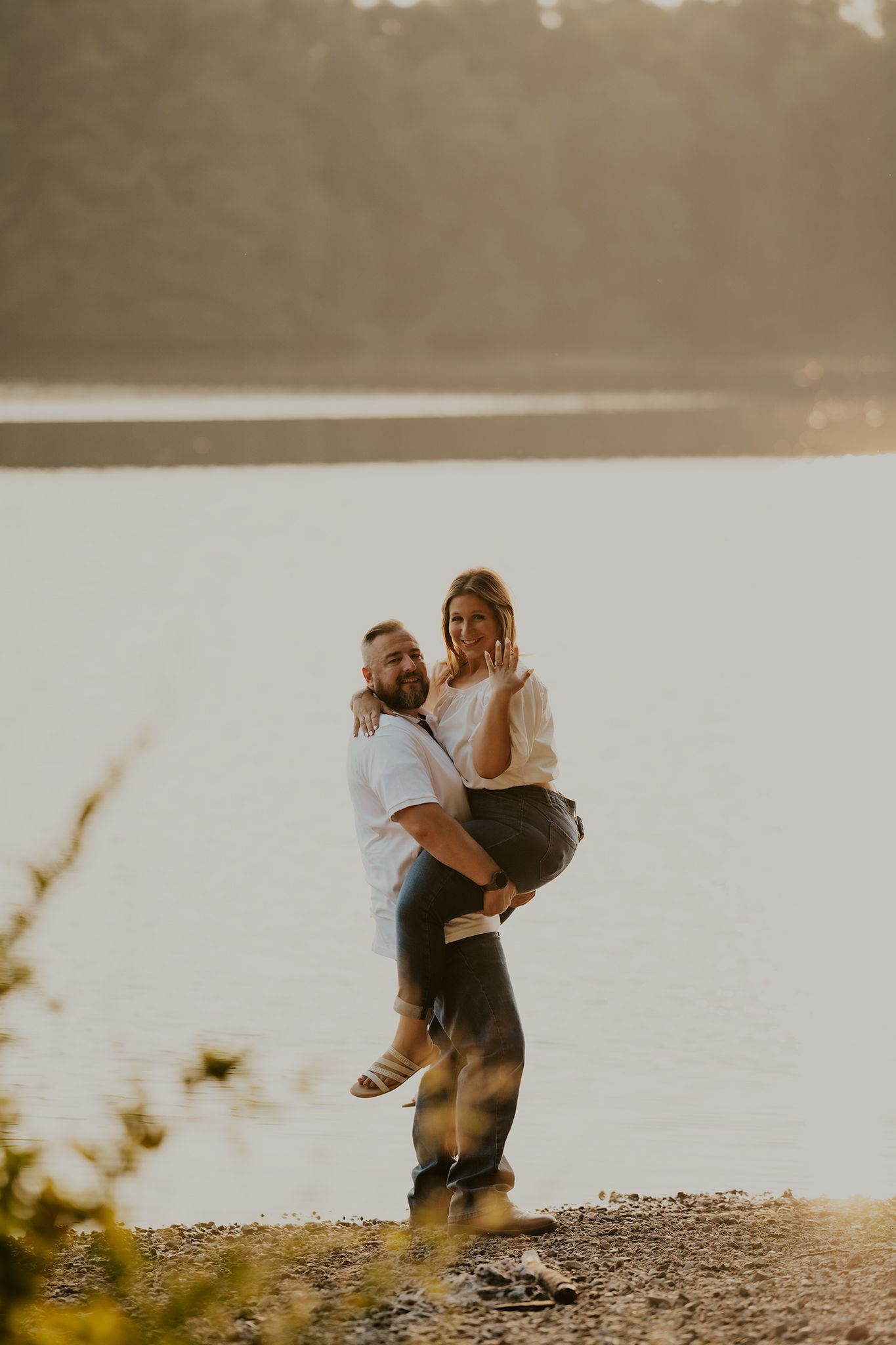 Two people embracing on a lakeside shore during sunset with multiple romantic poses captured in sequence.
