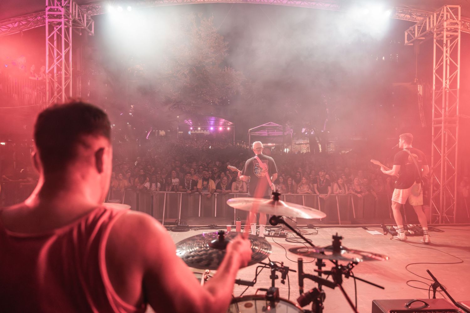 Drummer's perspective of a concert stage with fog and bright spotlights illuminating the performance.