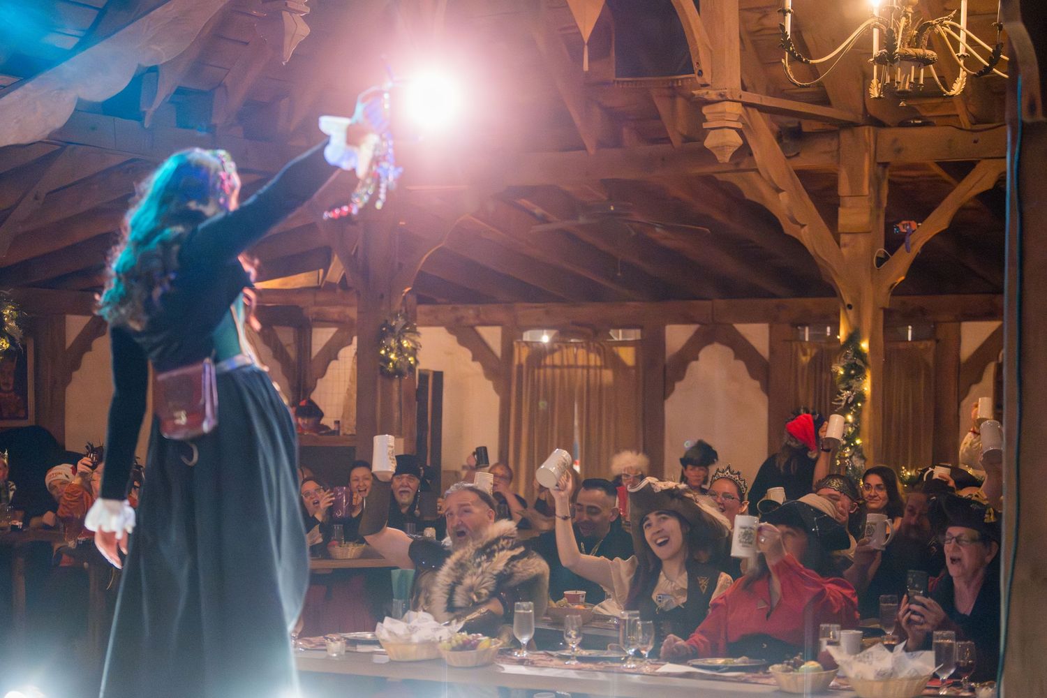 Performer on stage entertaining a crowd during an evening Renaissance festival show.