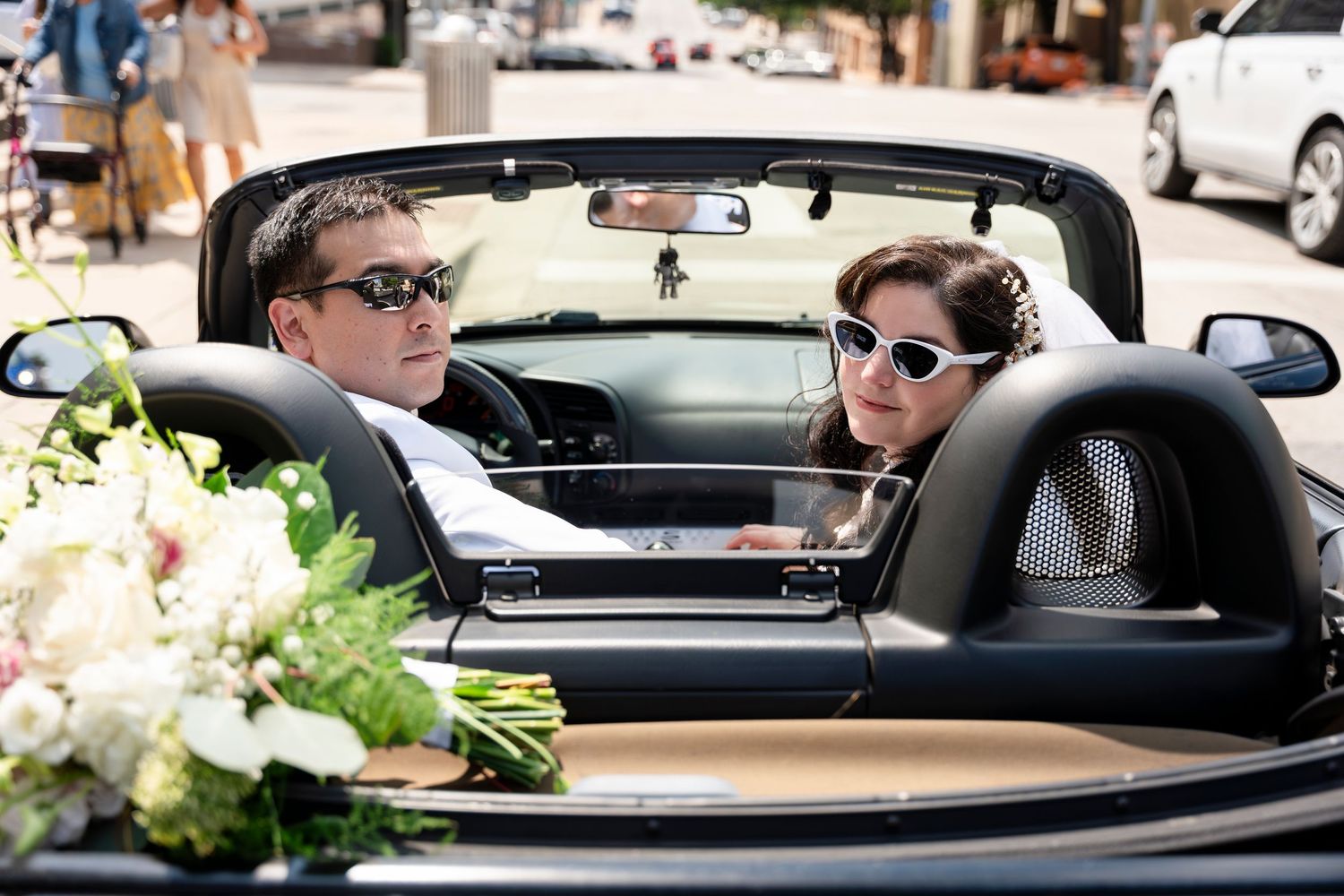 People talking in cars at sunset through rolled down windows in what appears to be a drive-through dining setup.