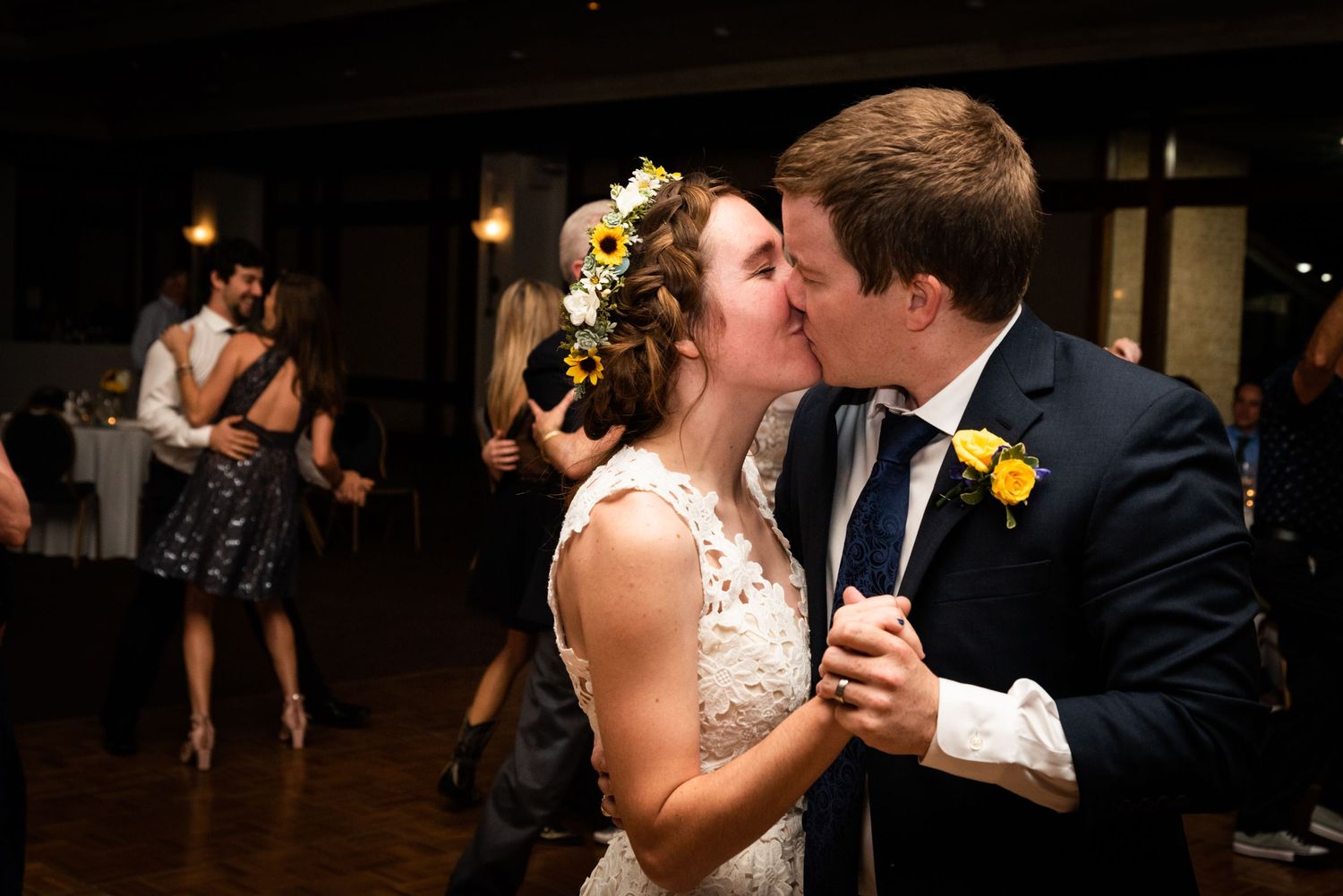 A romantic moment shared during a first dance at a dimly lit wedding reception.