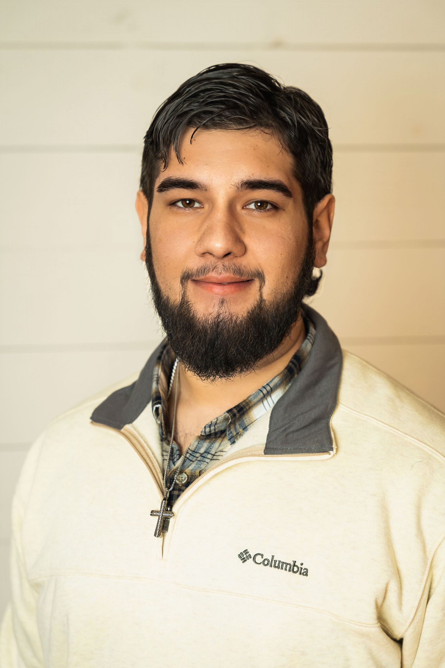 Portrait of person in Columbia fleece jacket and plaid shirt against light background.