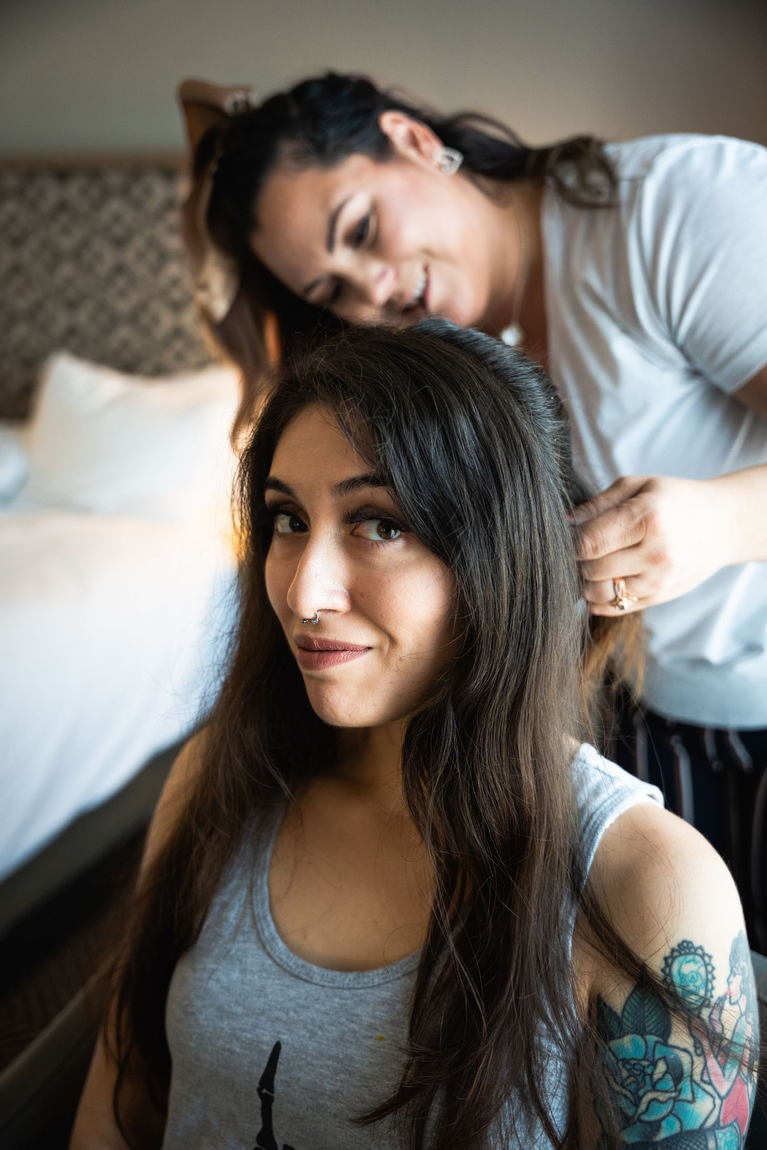 Intimate hair styling moment captured in soft natural light.