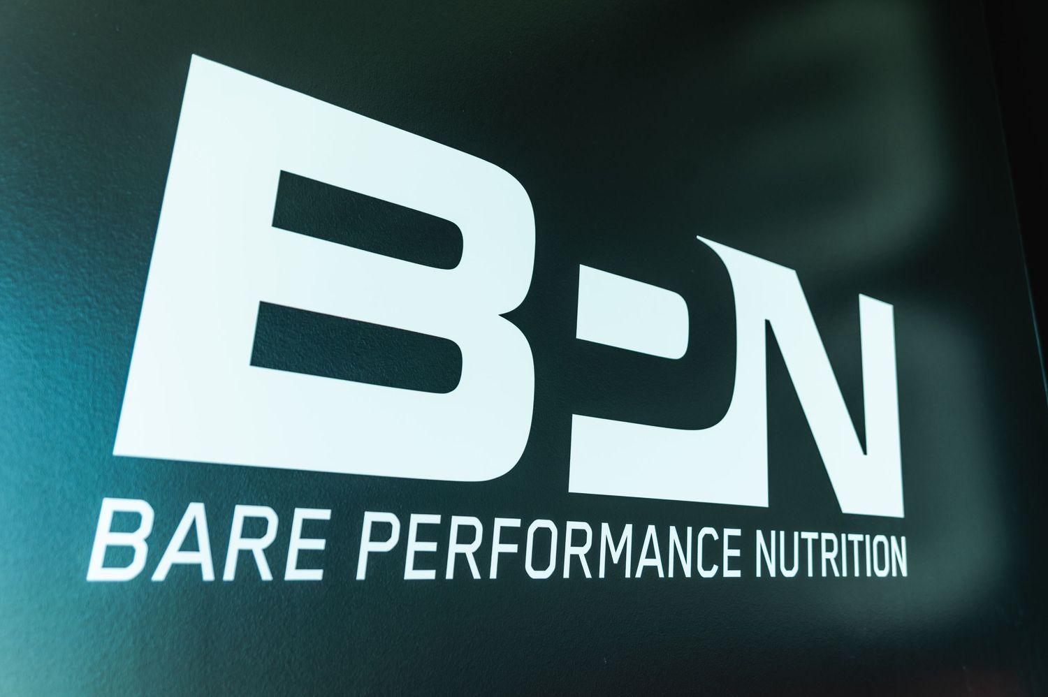 White BPN Bare Performance Nutrition logo displayed on dark background.