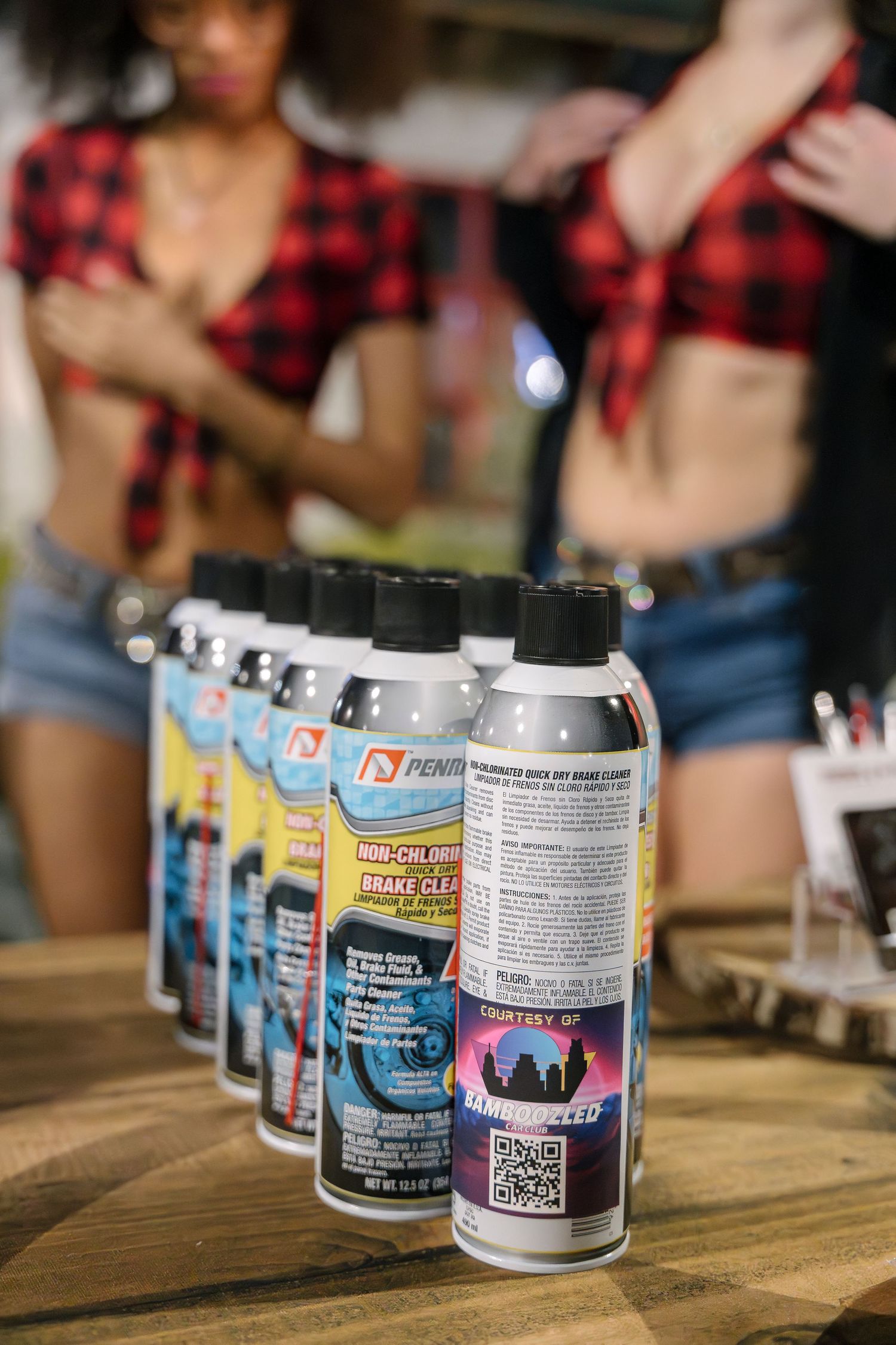 Row of colorful drink cans on wooden table with promotional branding.