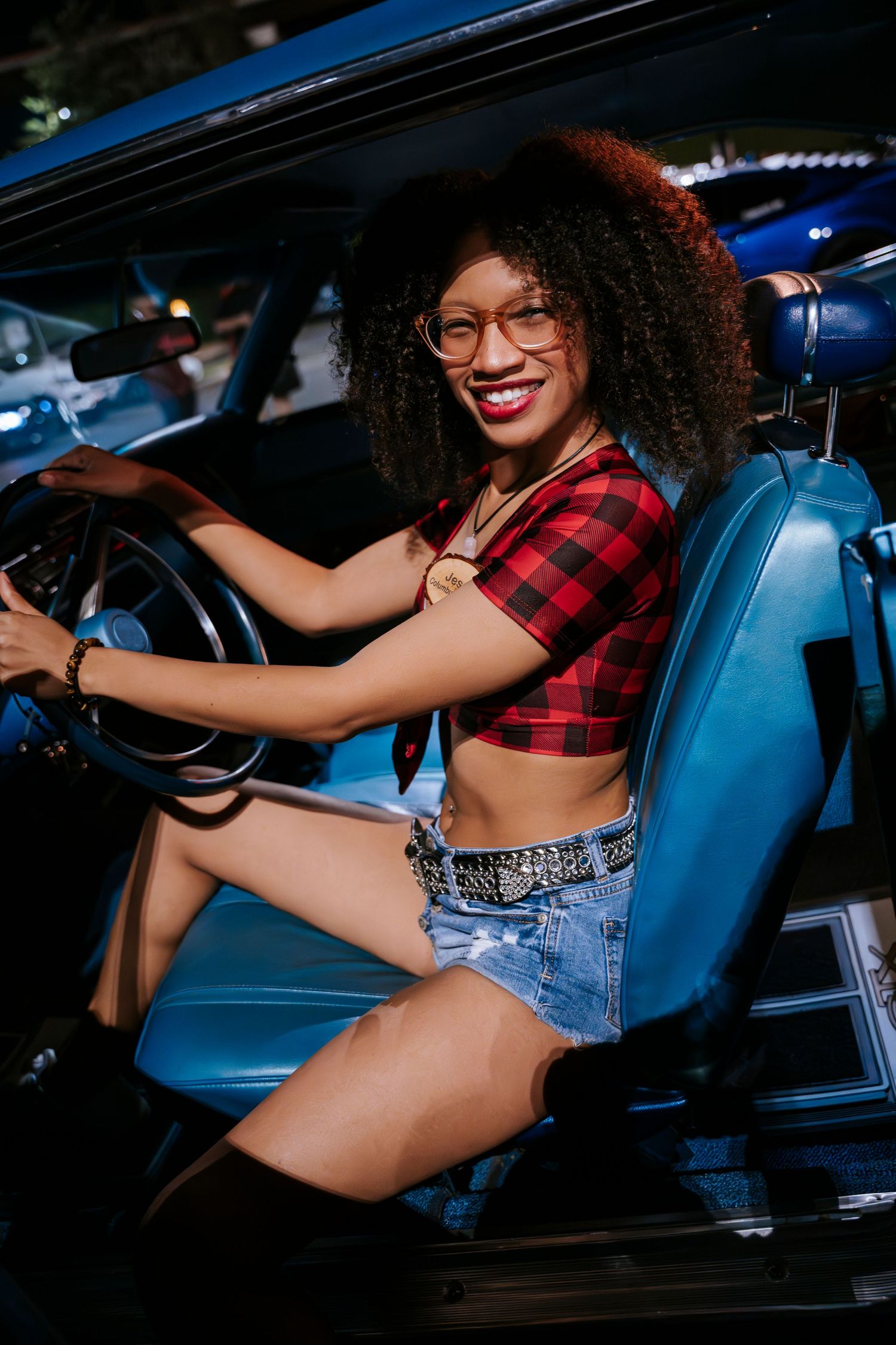 Casual retro-styled portrait inside vintage blue car with matching interior.