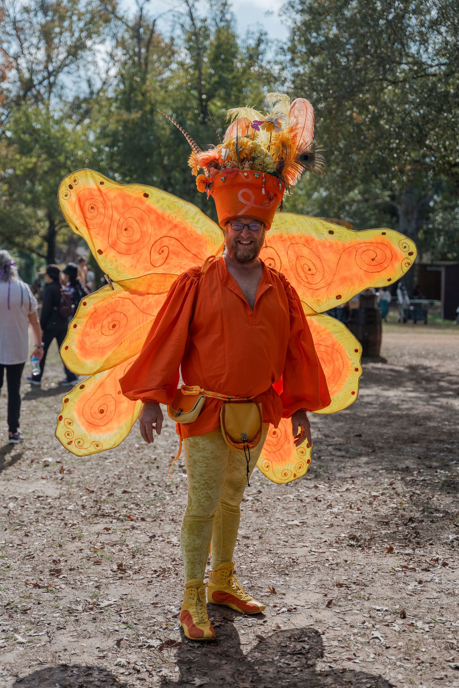 Performer wearing bright orange butterfly wings and costume at renaissance festival.