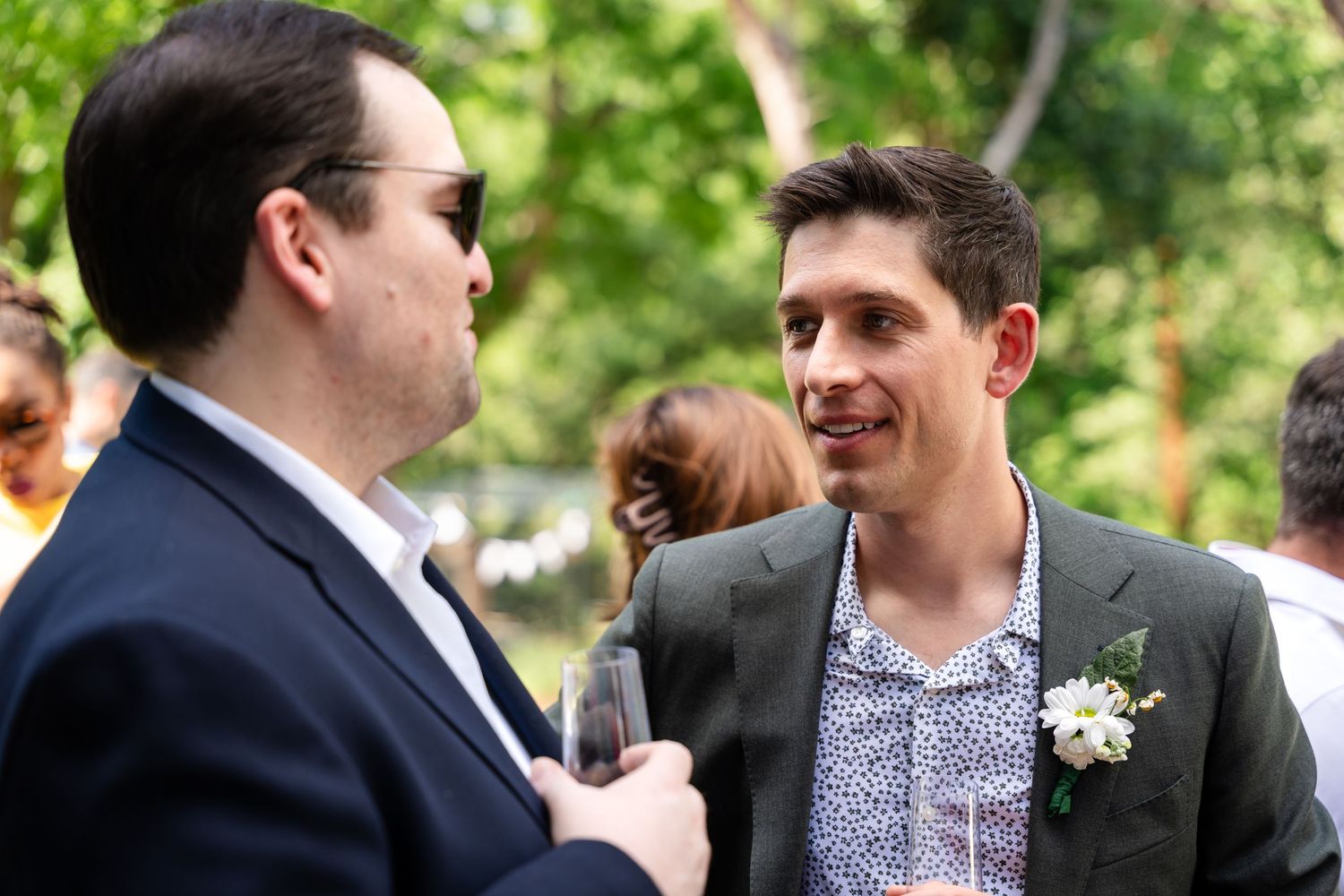 Two people engaged in conversation at an outdoor gathering.