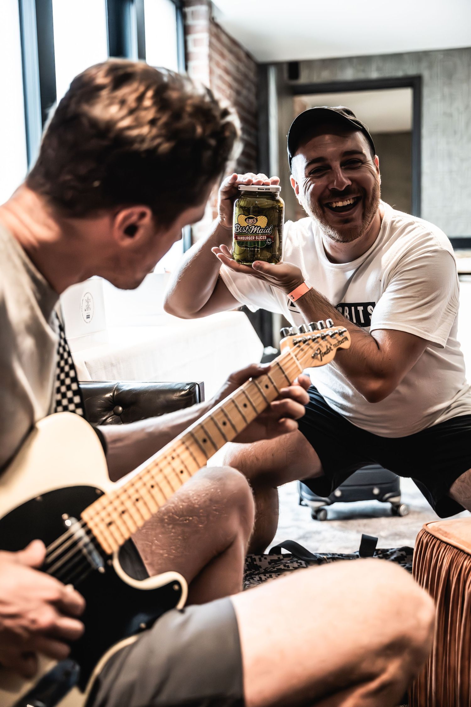 Two musicians rehearsing with guitars while sharing moments between songs.