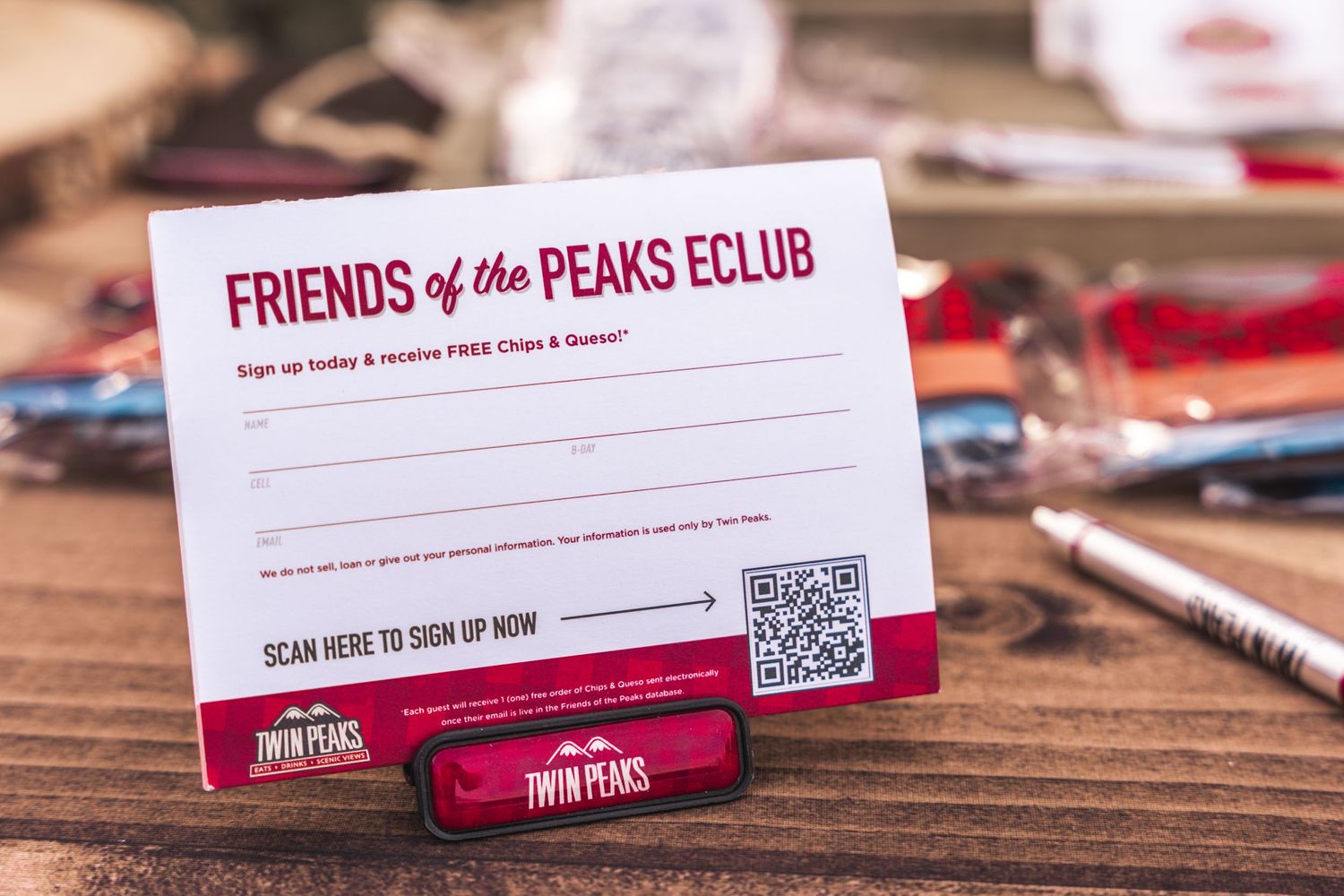Friends of the Peaks Club membership card with QR code on wooden table.