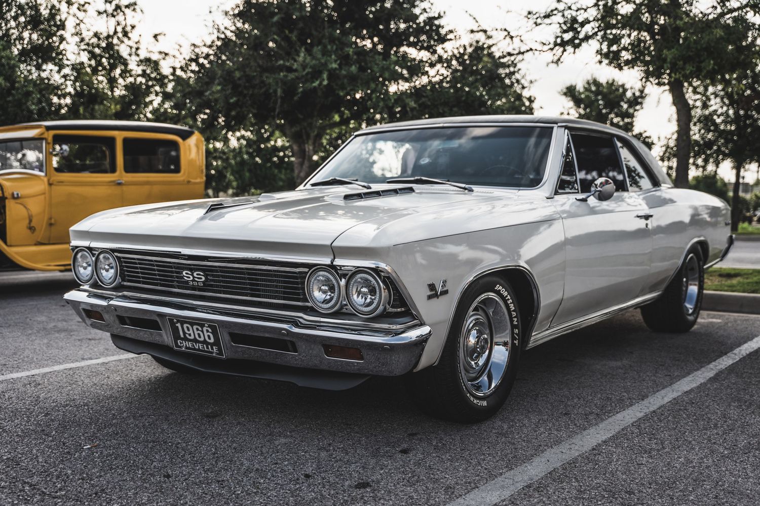 Classic silver Chevelle muscle car parked at automotive event.