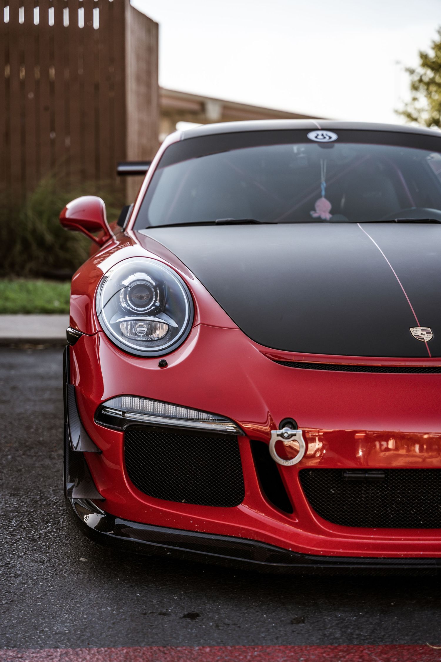 Close-up view of a red Porsche 911 GT3's front end showing distinctive headlight and hood details.