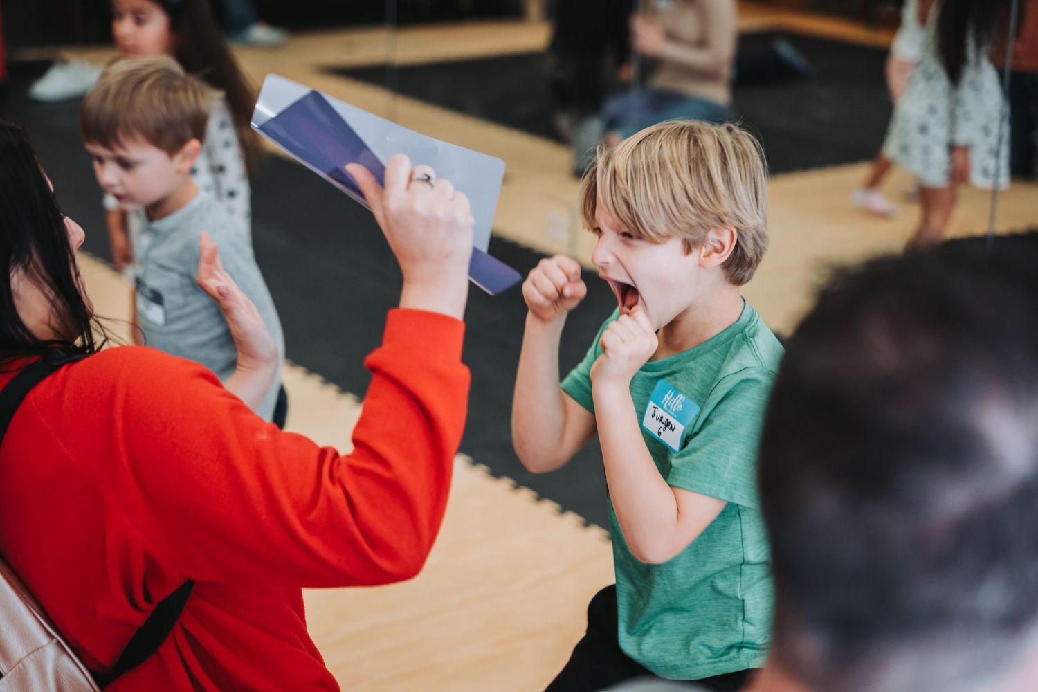 Student learns proper fighting stance while instructor holds training pad.