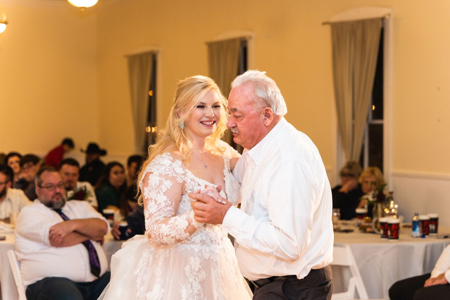 Emotional moment during a father-daughter dance at a wedding reception.
