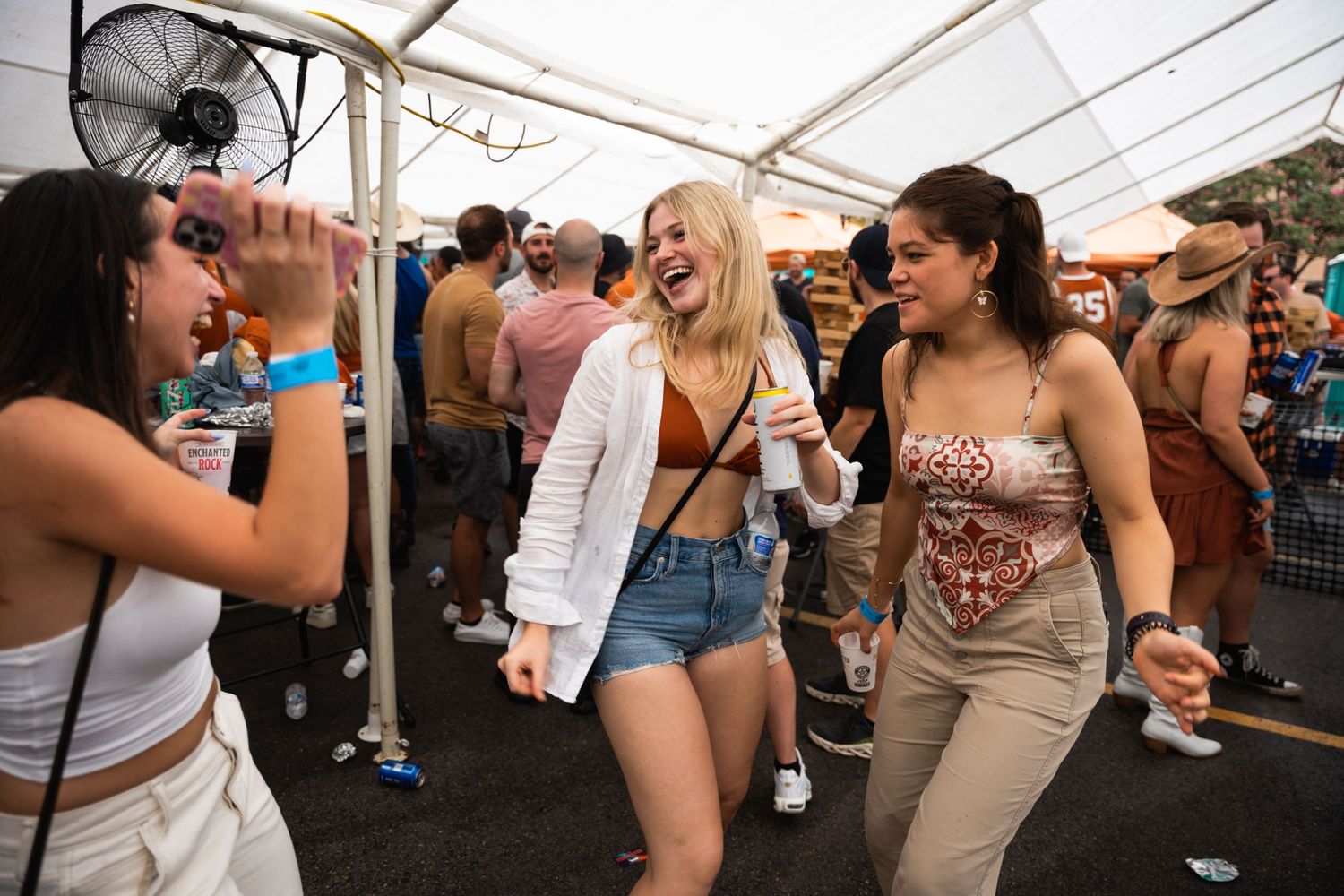 People dancing and having fun at an outdoor tent party.