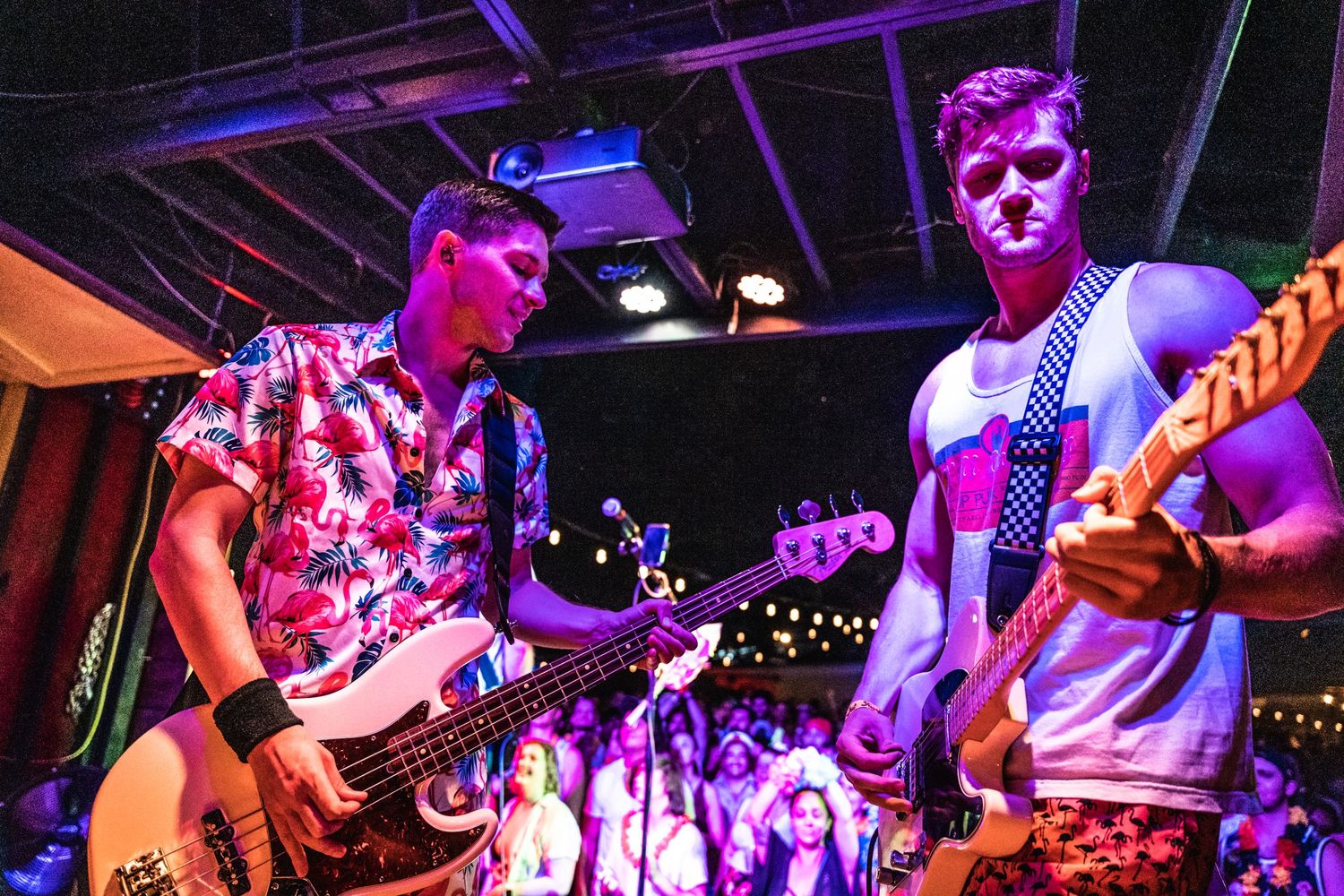 Musicians performing on stage with purple lighting and instruments.