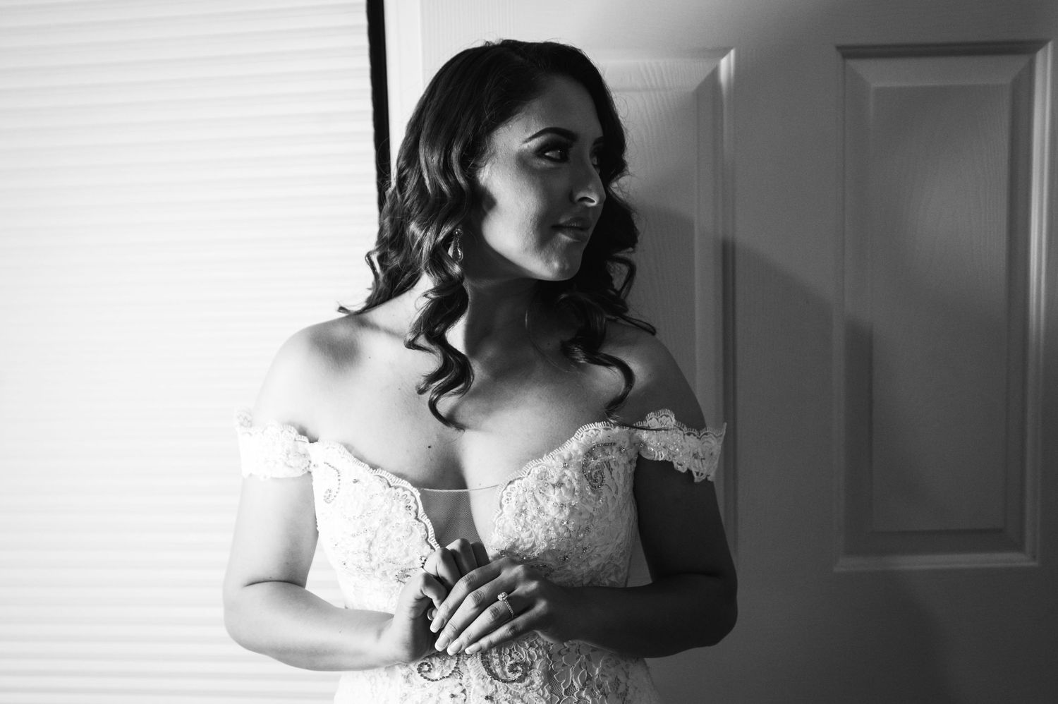 Elegant bridal portrait in black and white showing off detailed lace wedding gown.