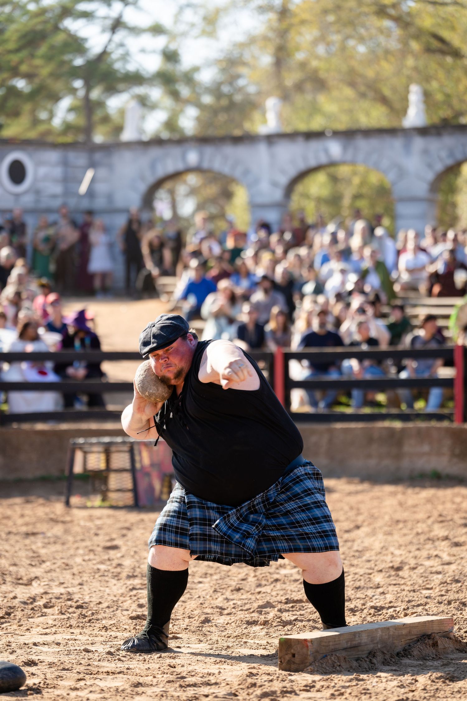 Three sequential photos show two kilted athletes competing in a traditional Scottish heavy athletics event in a dirt arena.