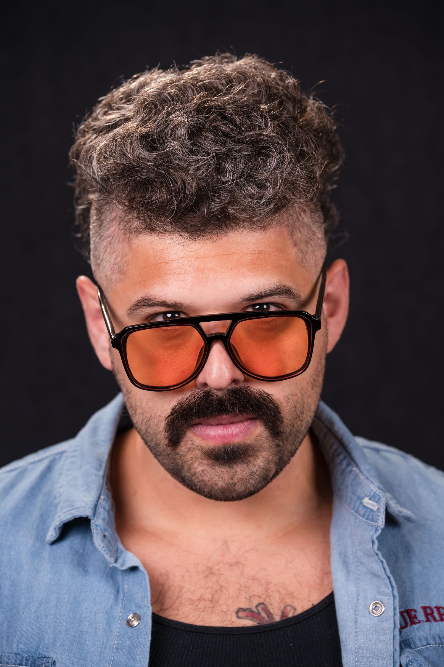 A series of close-up shots showing someone wearing orange-tinted sunglasses and a light blue button-down shirt.