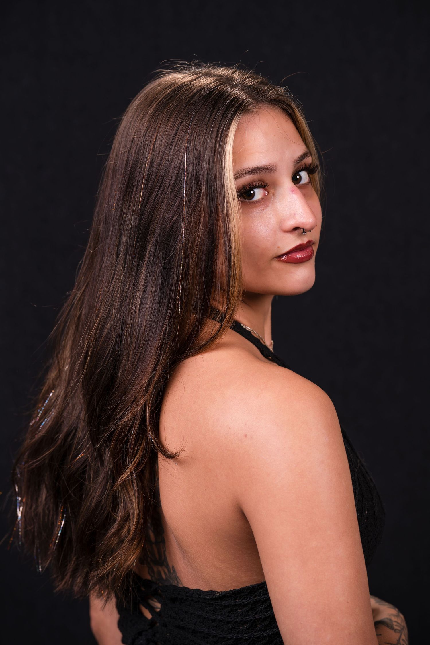 A series of glamour portraits showing a person with dark hair in a black dress against a dark background.