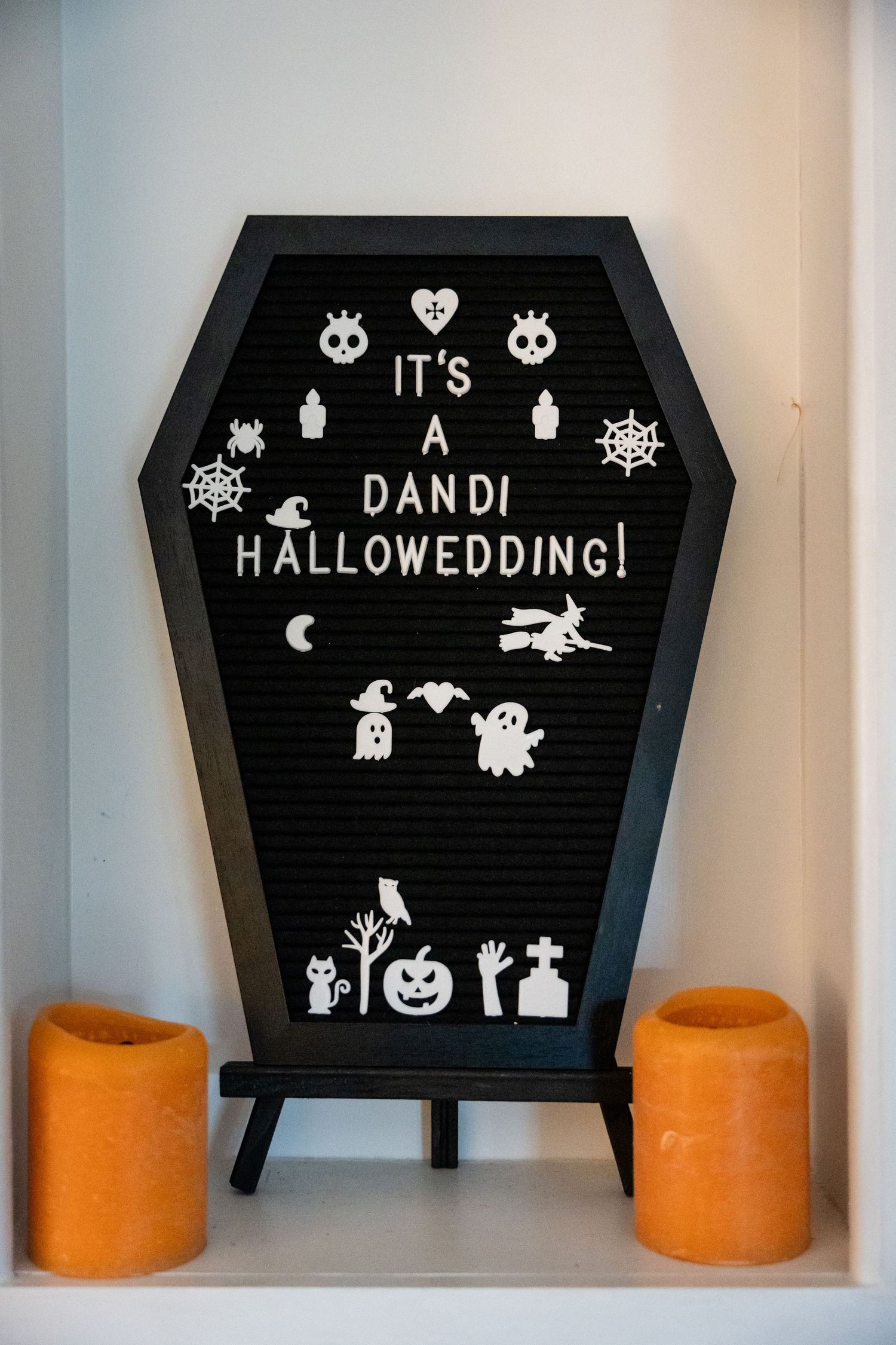 Black coffin-shaped letter board with Halloween-themed decorations announcing 'It's A Dandi Halloween Wedding'.