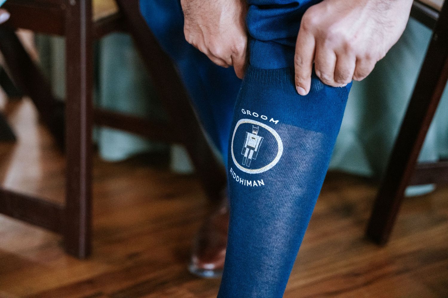 Close-up detail of blue wedding socks with custom logo design.