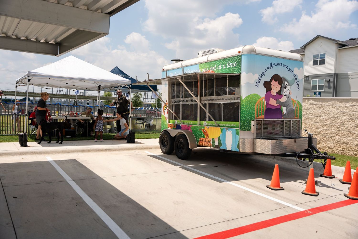 Food trucks and mobile vendors parked in a commercial parking lot during daytime.