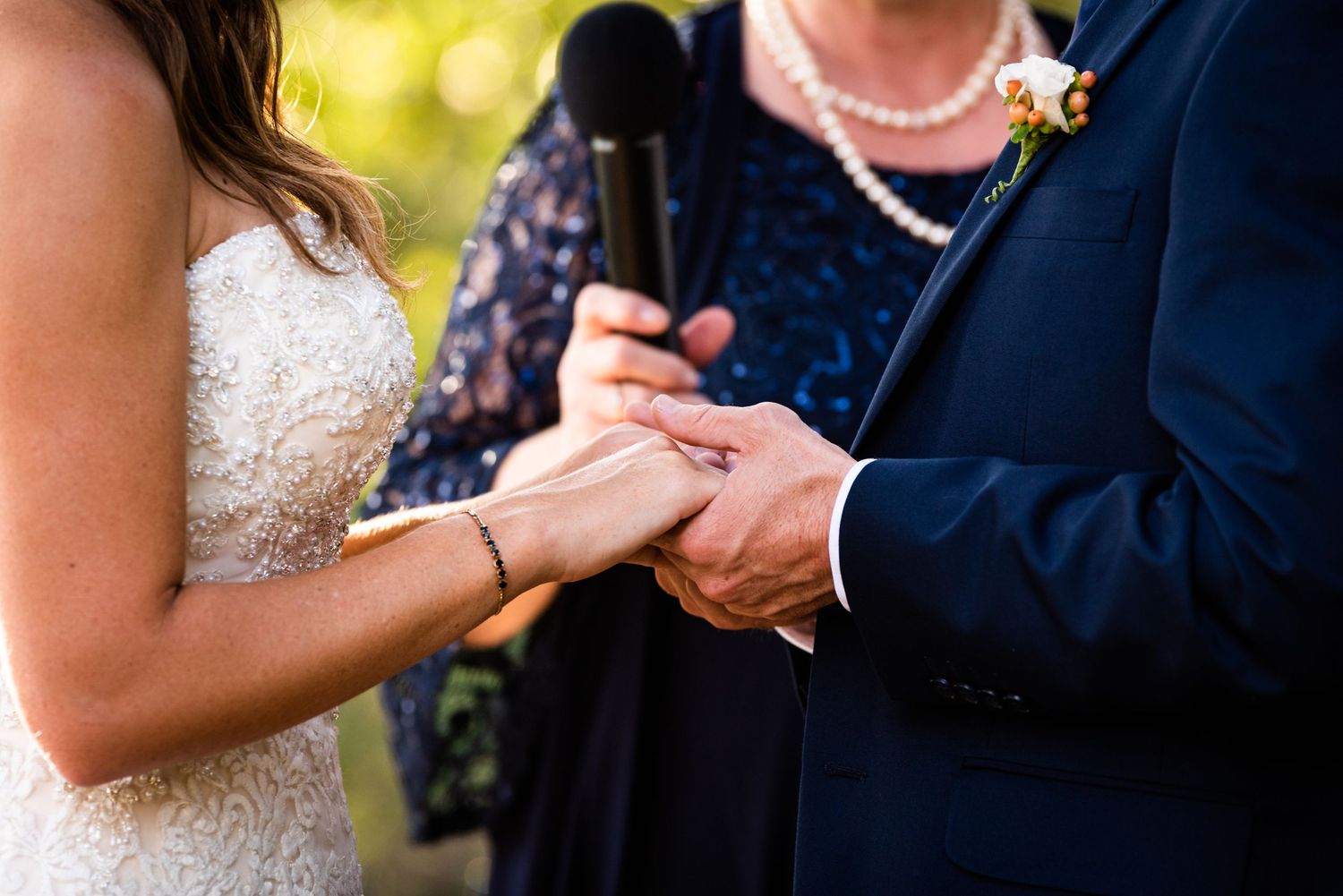 Close-up of hands exchanging rings during wedding ceremony.