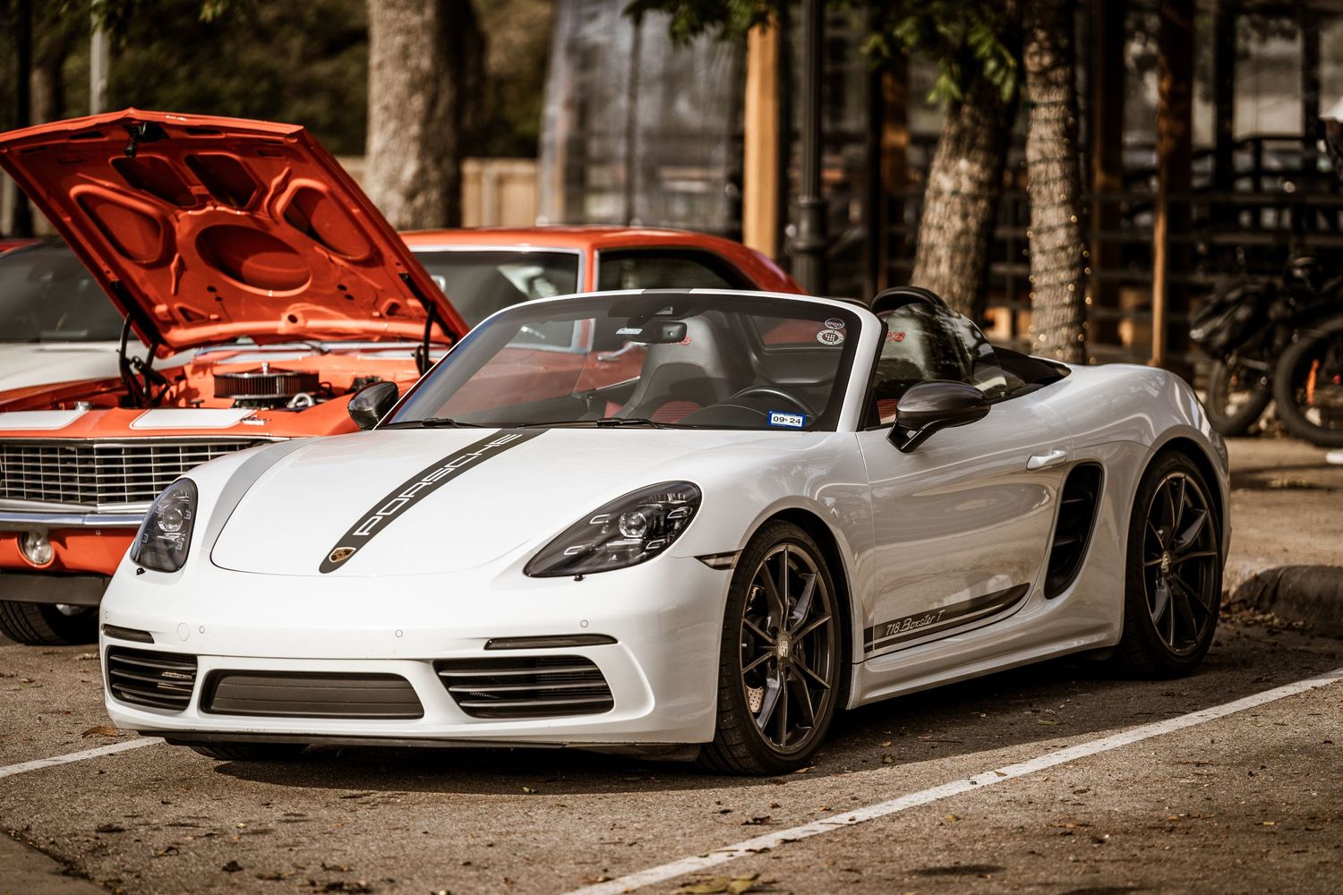 White Porsche Boxster convertible sports car displayed at outdoor event.