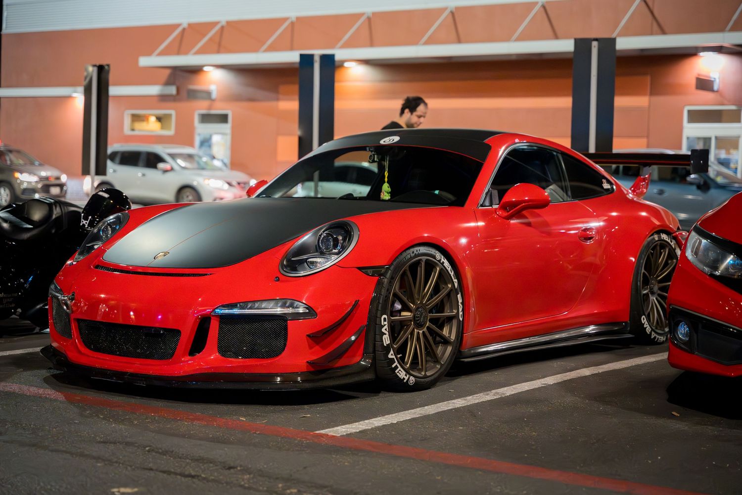 A red Porsche GT3 RS showcasing its aggressive styling in a parking lot.