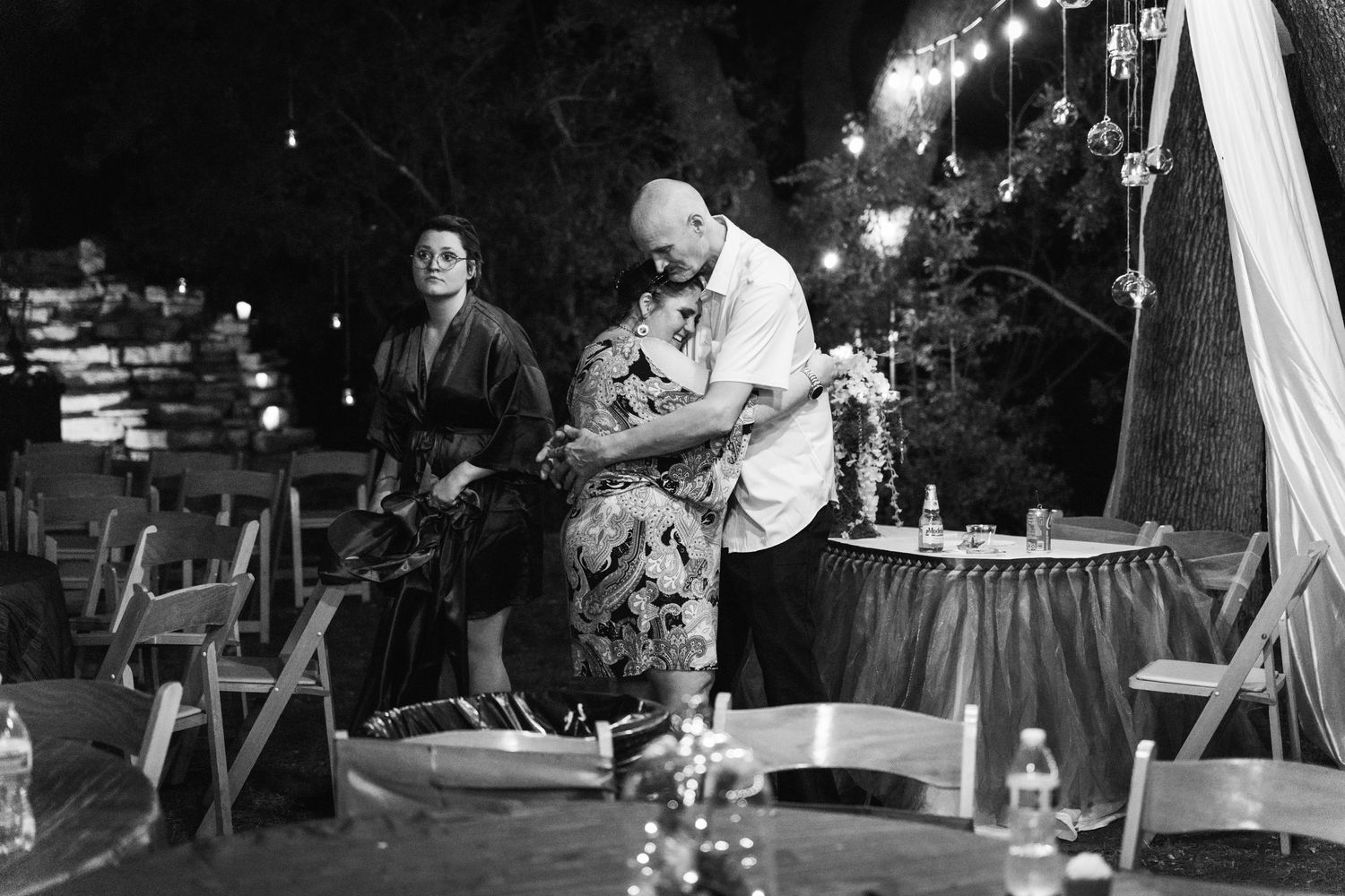 A black and white photograph captures dancing couples at an evening reception.