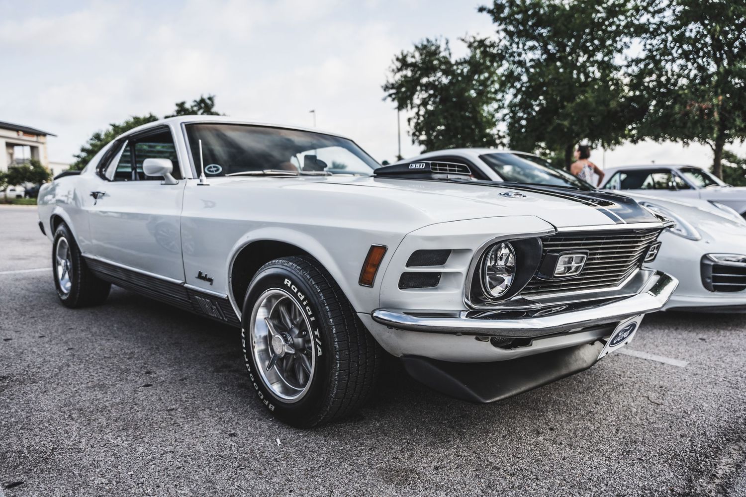 Side profile of white 1970 Ford Mustang with chrome trim and wheels.