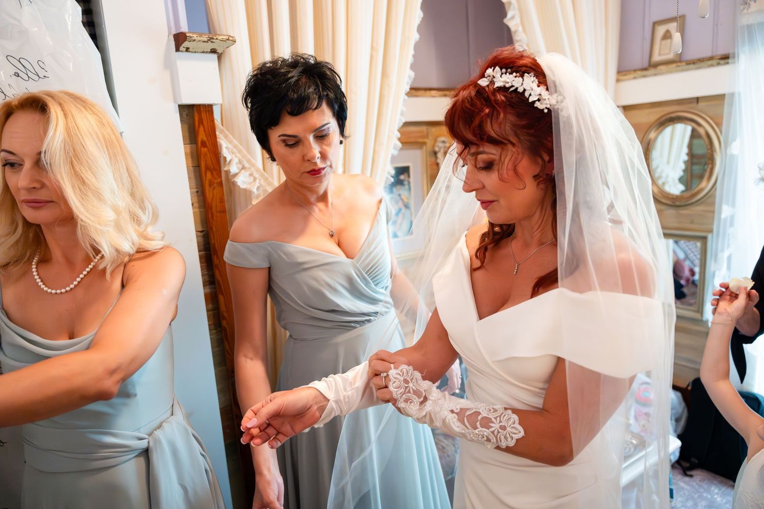 Wedding preparations showing bridal attendants in pale blue dresses helping with final details.