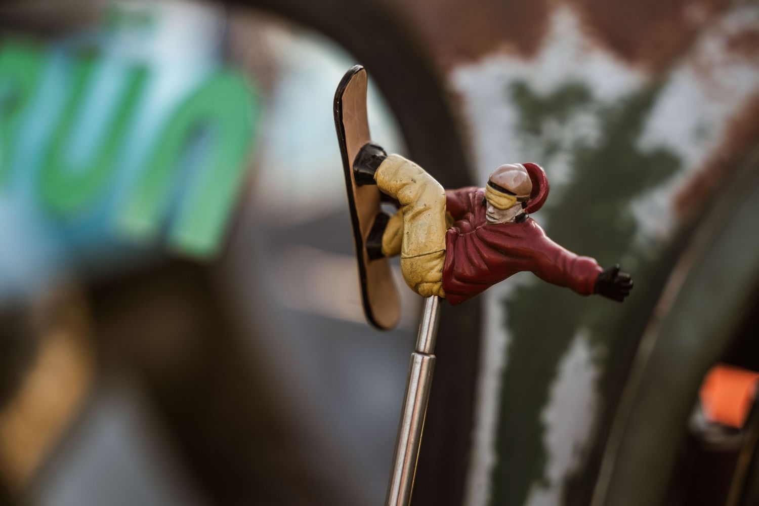 Small decorative figure doing a skateboard trick mounted on a car antenna.