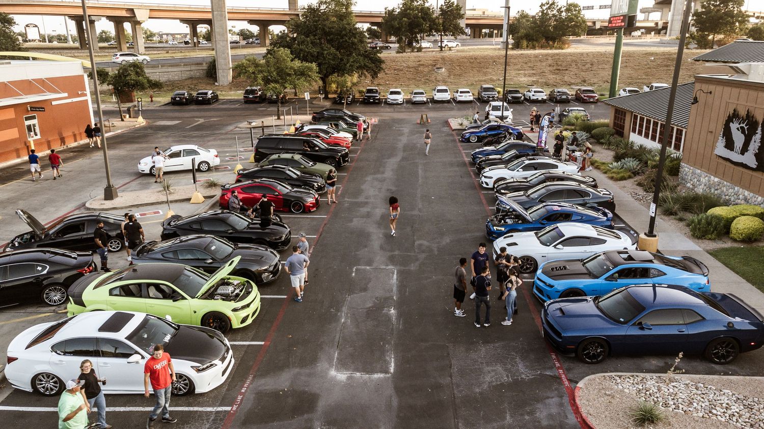 Bird's eye view of parked cars in a shopping center lot.