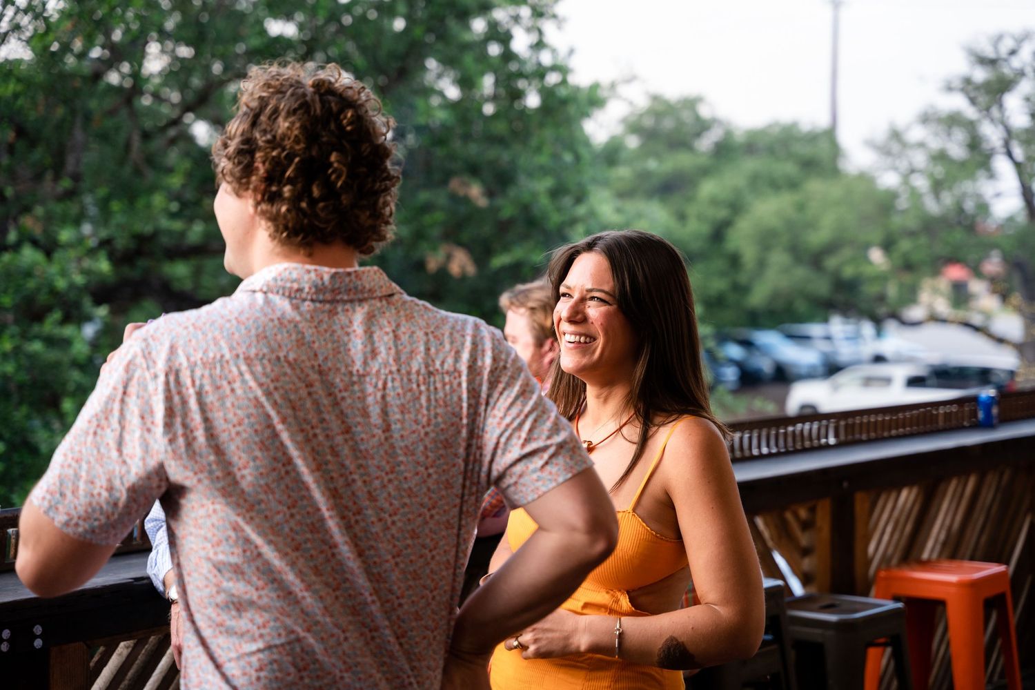 Two people engaged in conversation on an outdoor patio during daytime.