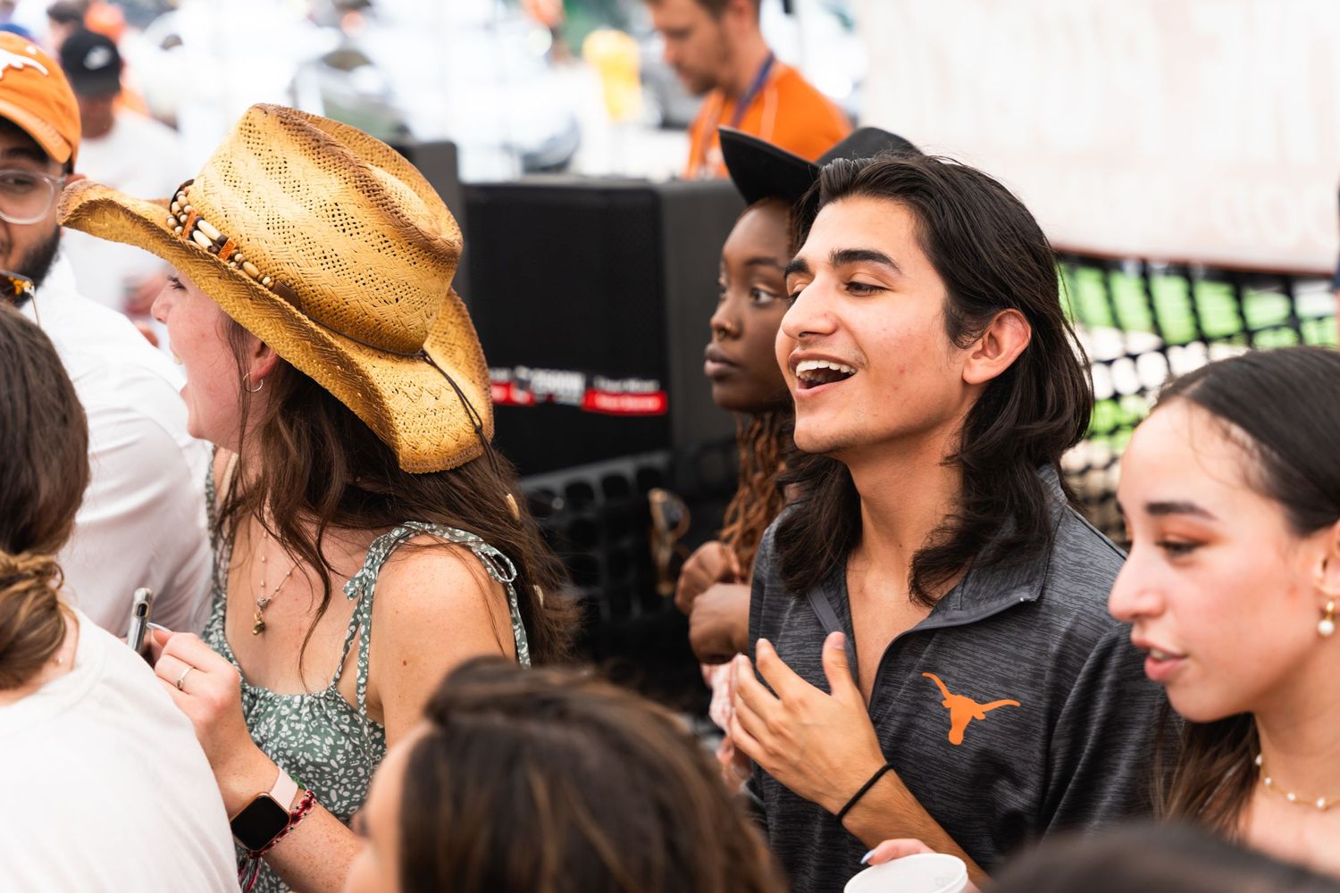 Energetic crowd dancing and celebrating at what appears to be a Texas-themed outdoor event.
