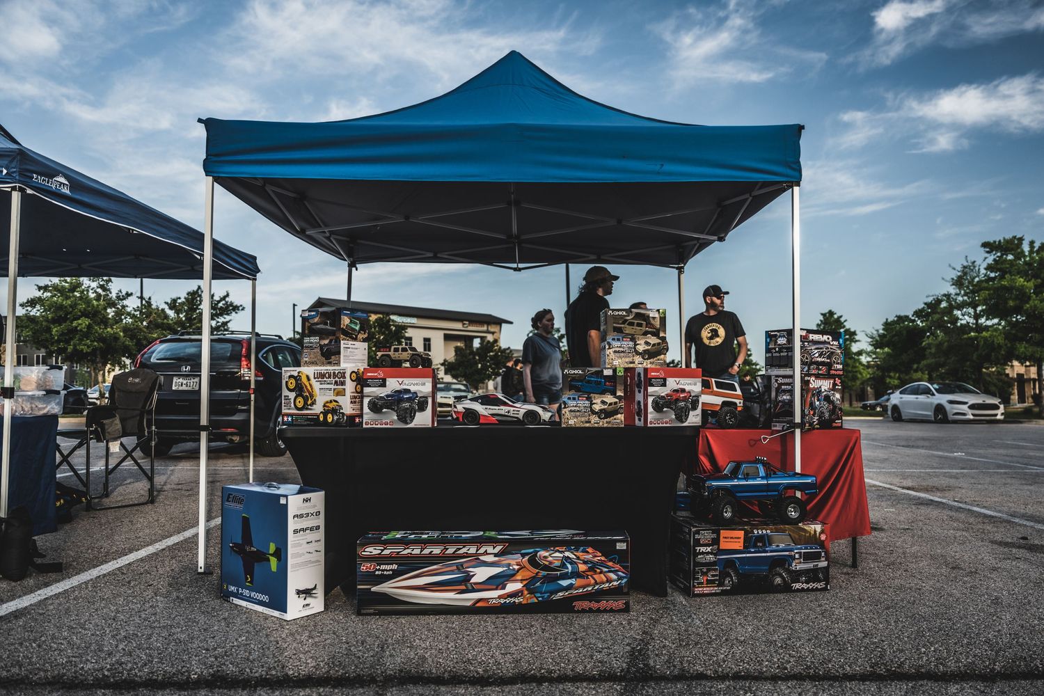 Outdoor vendor booth with blue canopy displaying merchandise at a local market.