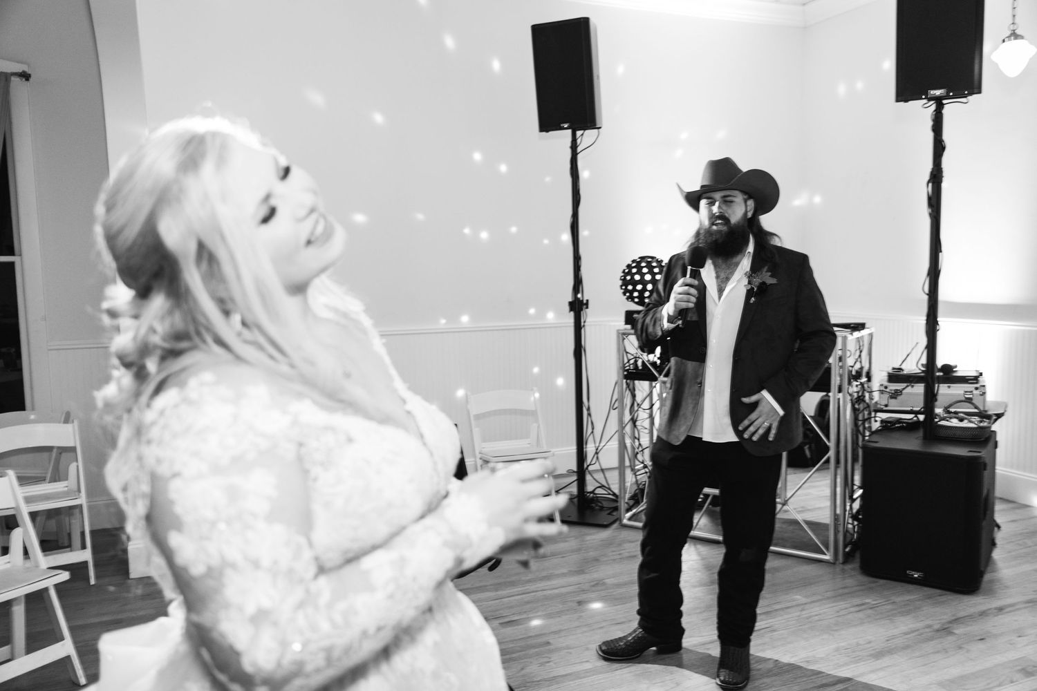 Black and white photo of wedding entertainment performance with speakers visible in the background.