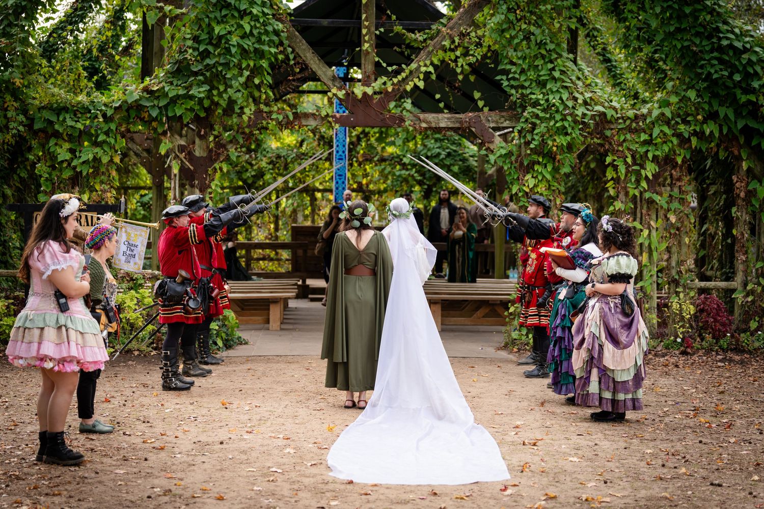 Bride and groom share a romantic moment during outdoor wedding ceremony surrounded by guests in wooded setting.