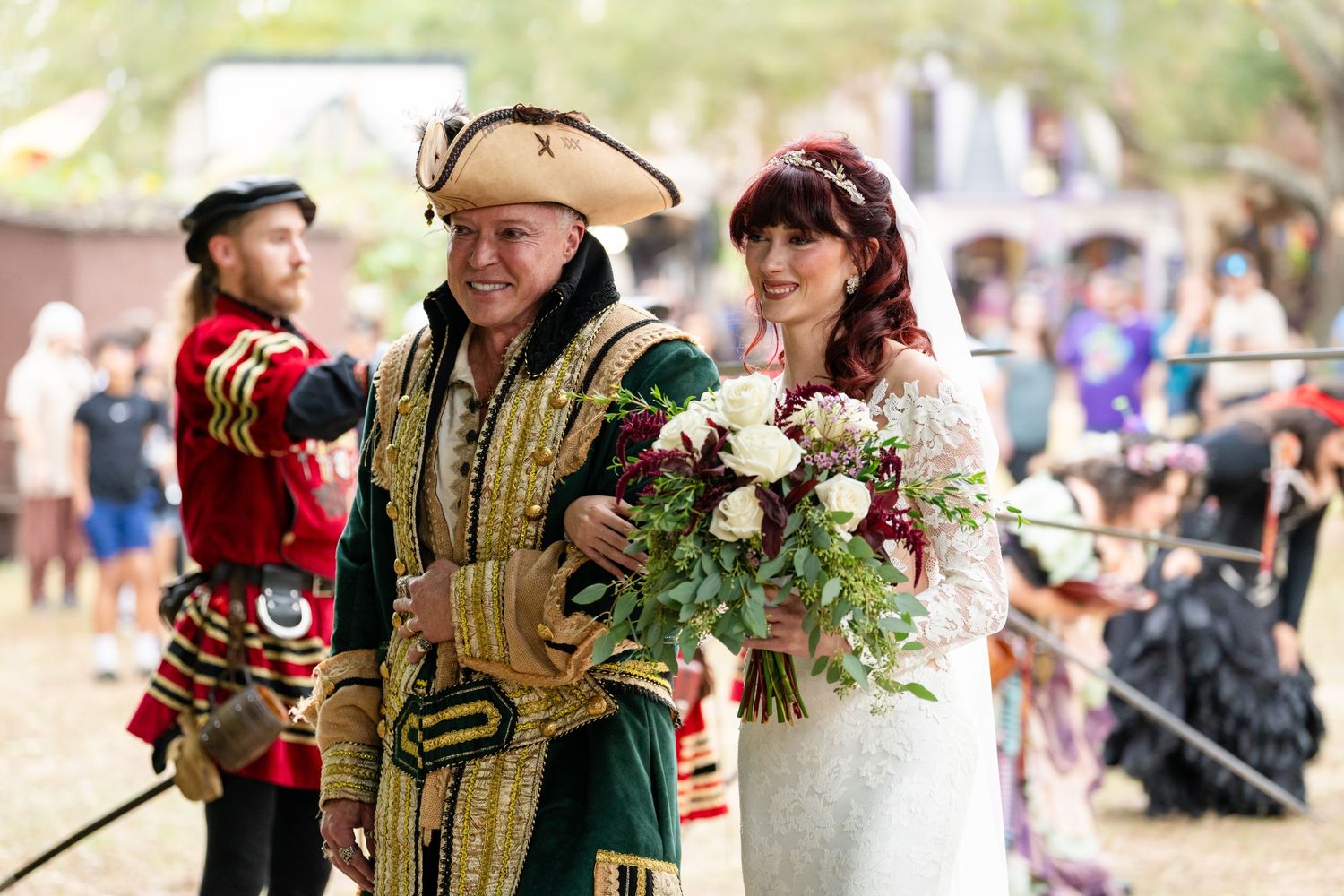 A group of people in medieval costumes enjoying a renaissance fair with colorful period clothing and decorations.
