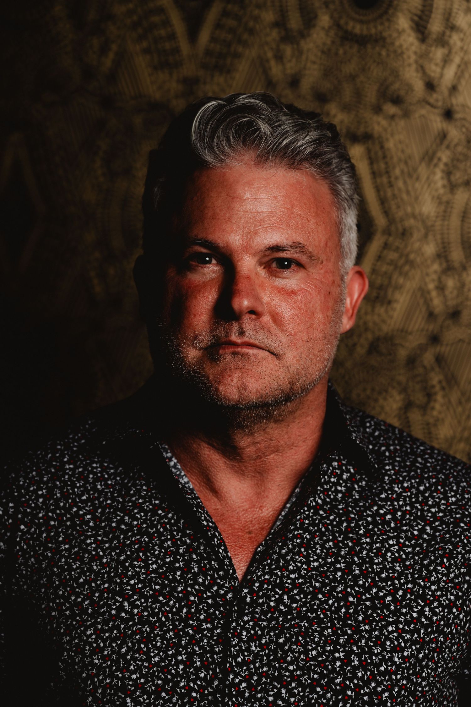 Portrait photo series showing person in dark polka dot shirt against textured background with dramatic lighting.