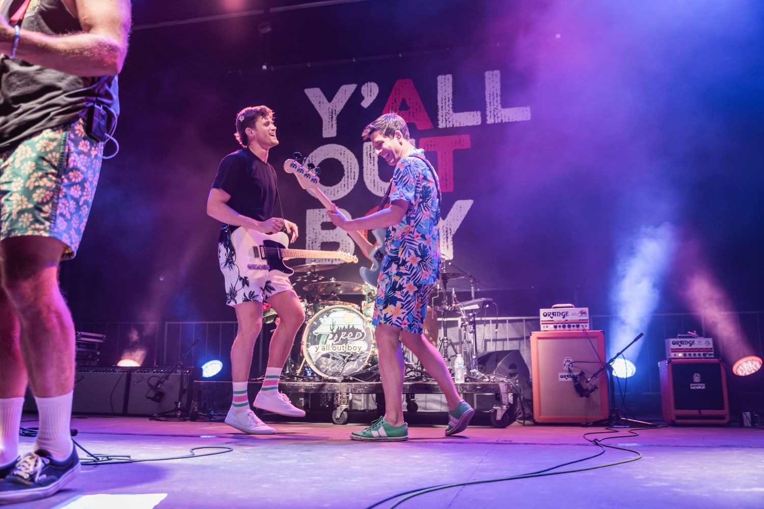 Dancers perform energetic breakdancing moves on a colorfully lit stage with 'Y'ALL' text visible in the background.