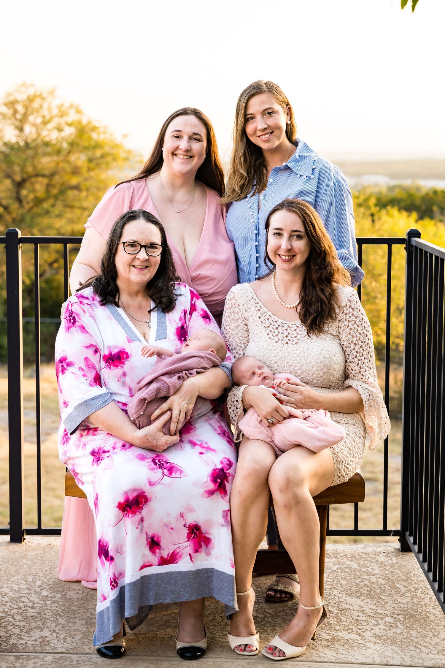 Group seated together on outdoor patio with infant during golden hour.