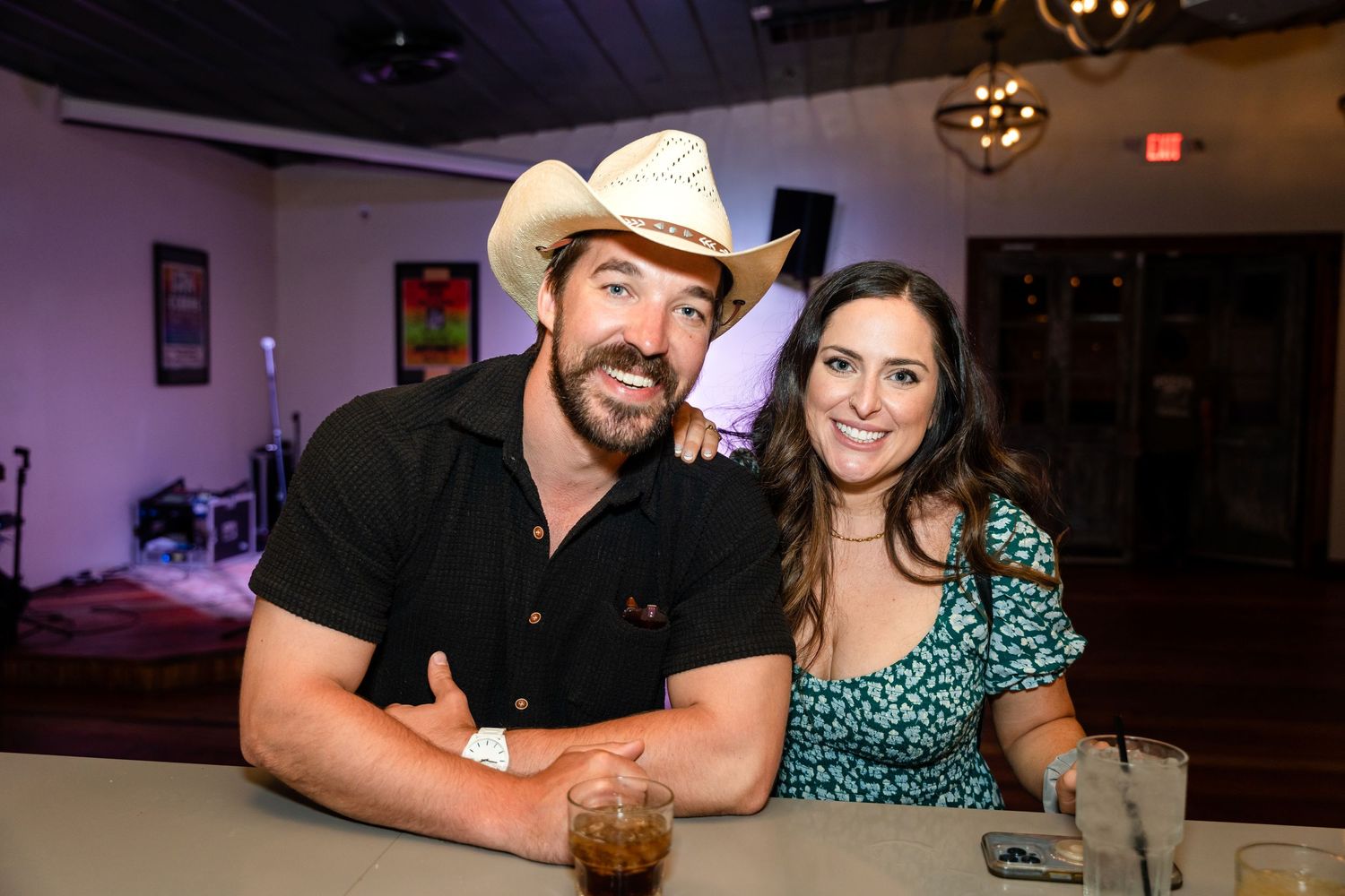 A couple enjoys a casual evening at a bar venue with dim lighting and western decor.