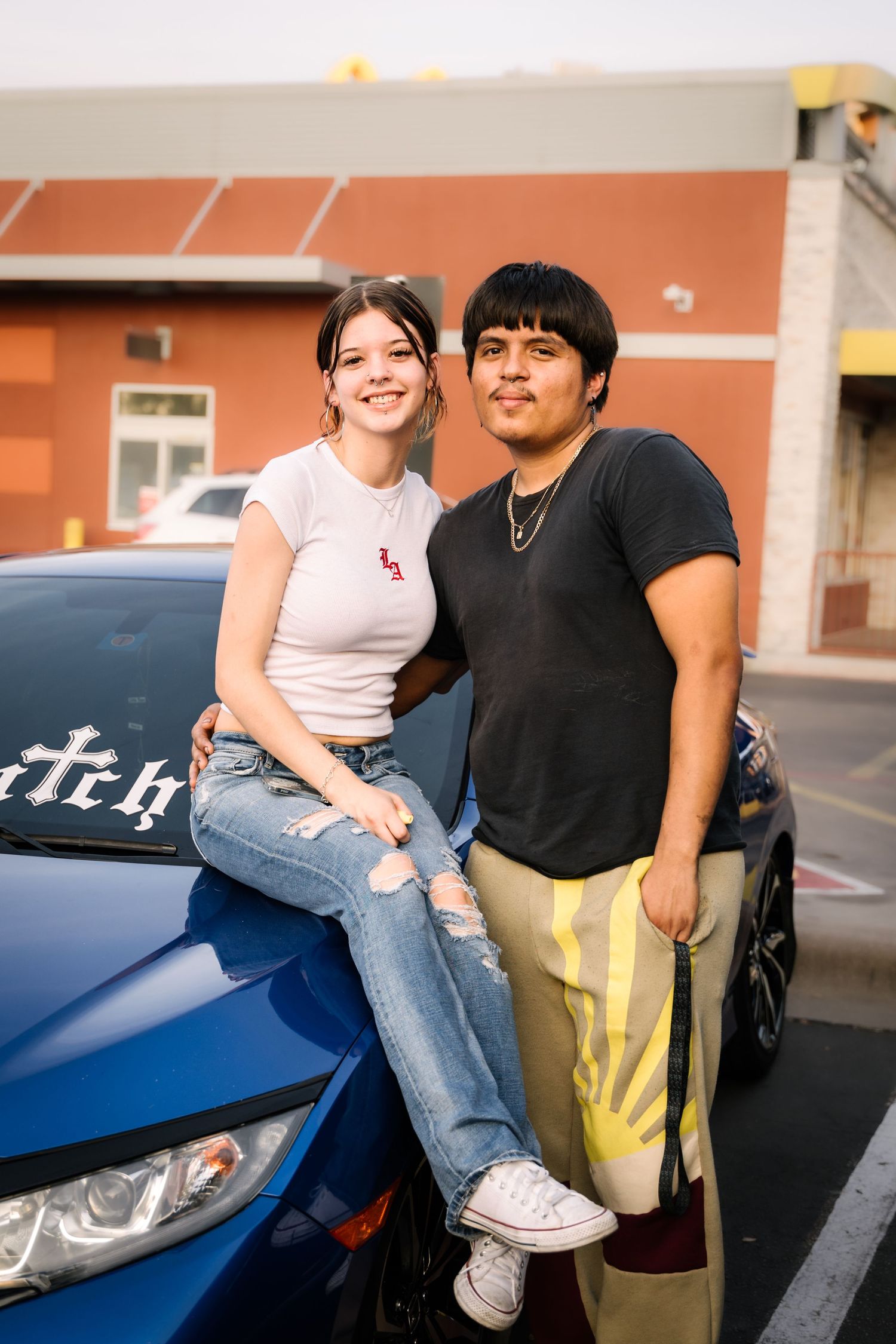 Casual automotive event photo against blue modern car.