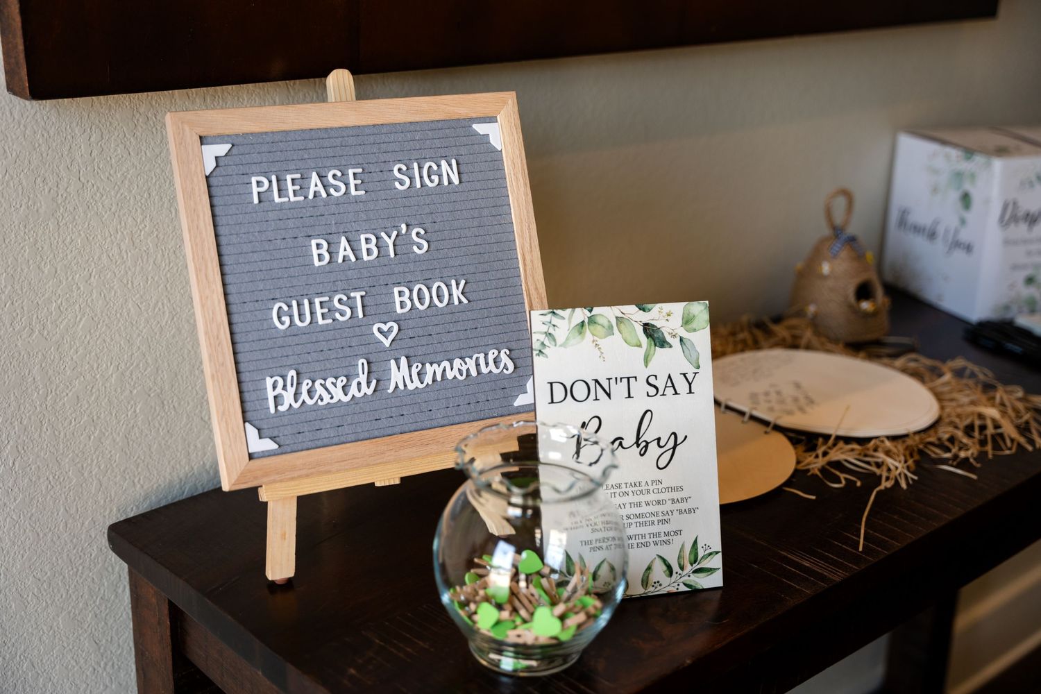Baby shower guest book display with letterboard sign and decorative elements.