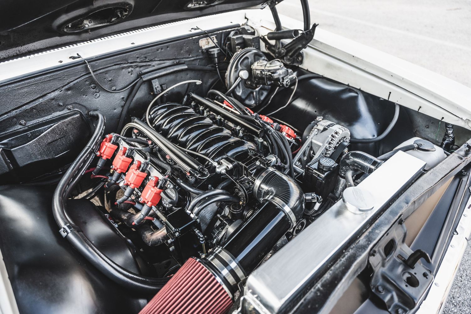 High performance V8 engine bay showing custom modifications and red fuel rails.