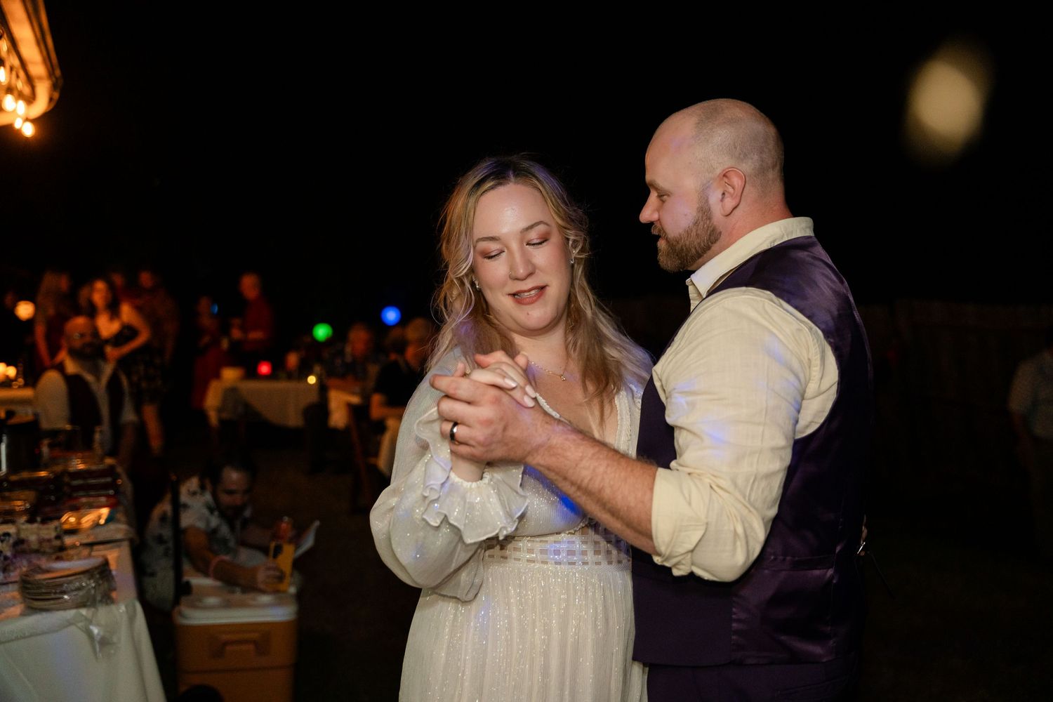 Couple shares romantic dance during evening wedding reception.