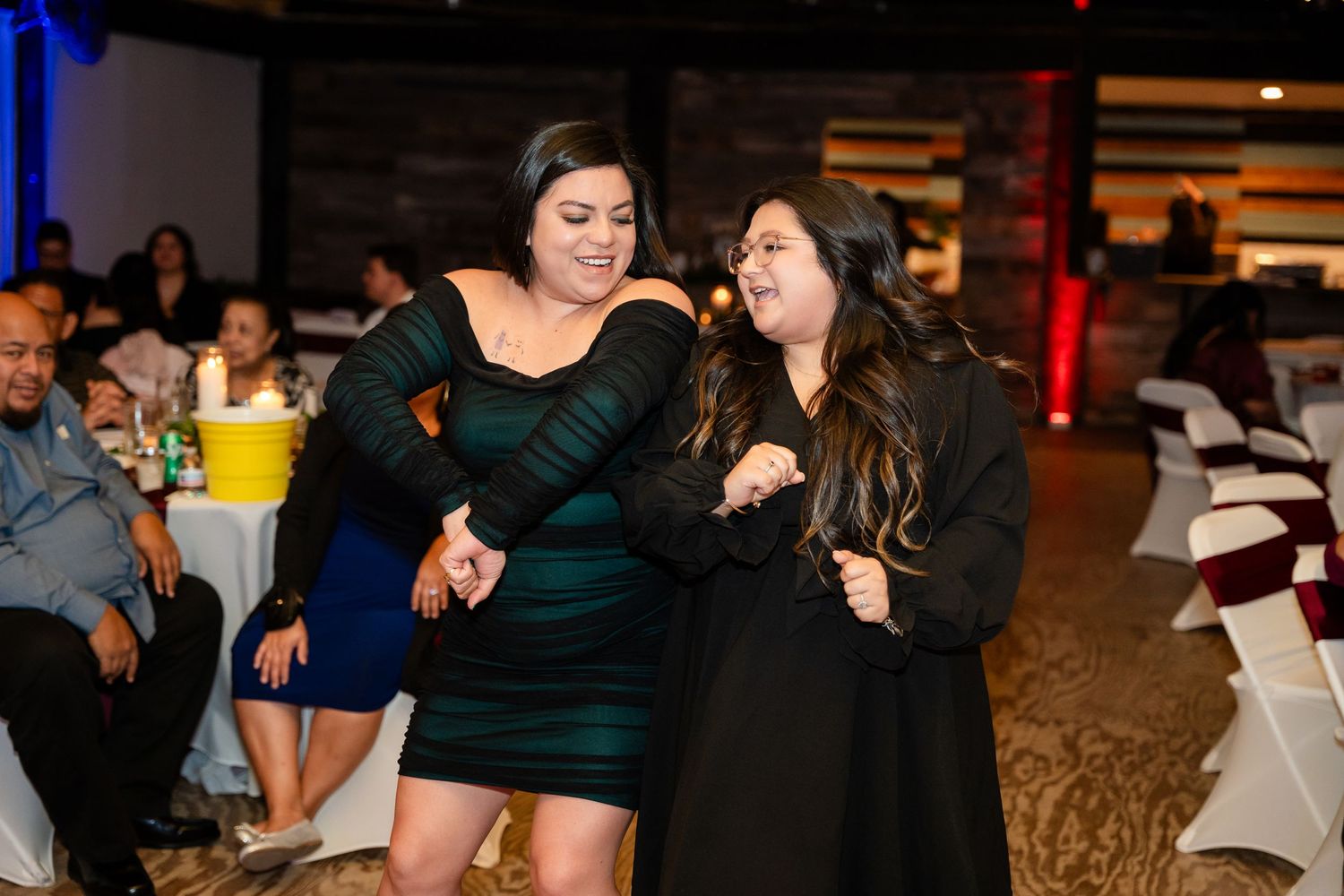 Two guests having fun dancing and singing together at a celebration event.